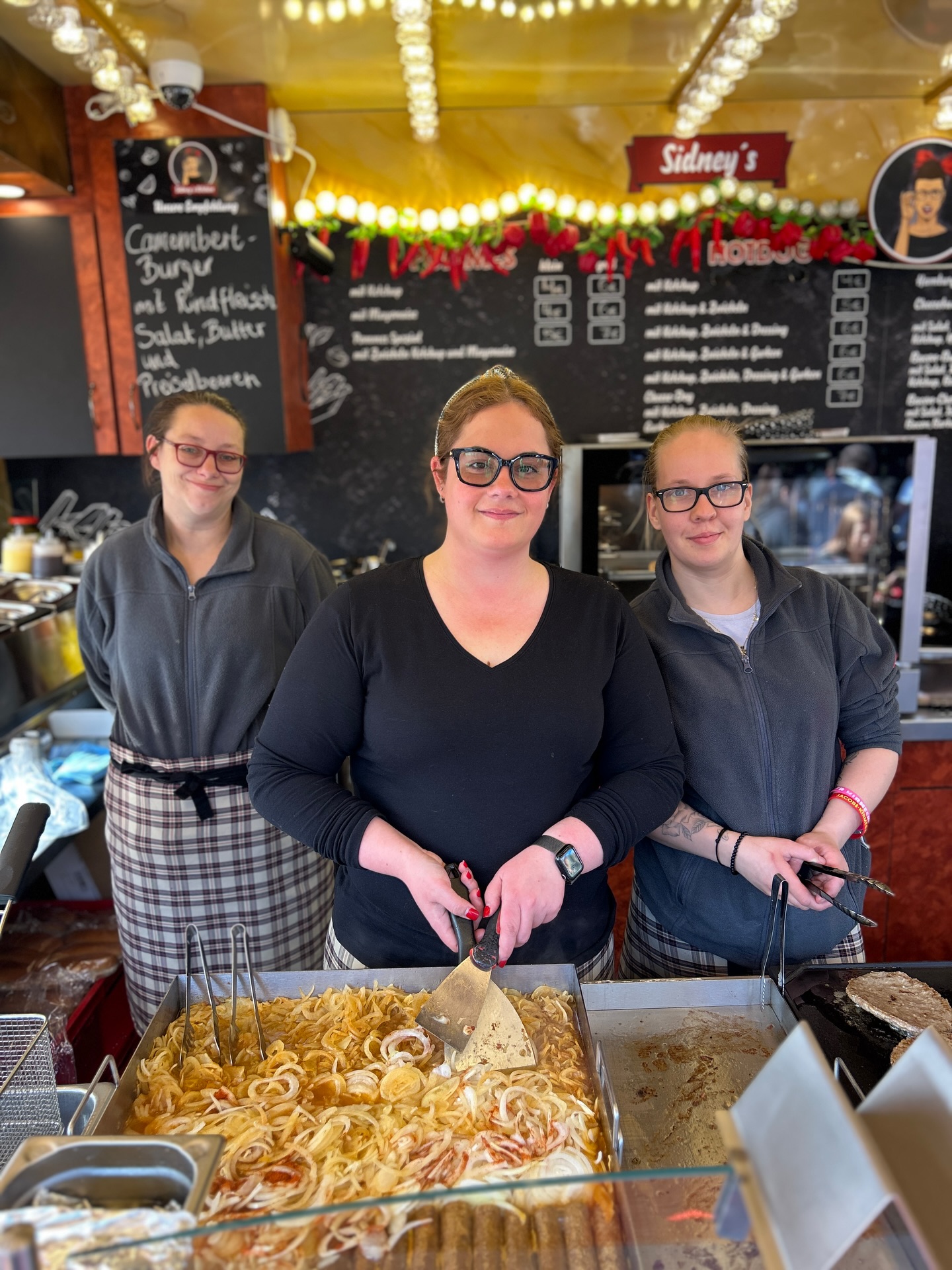 Zwischen Tradition & Vorfreude…
Was macht die Dortmunder Weihnachtsstadt eigentlich so besonders?
Für viele Schaustellerinnen und Schausteller ist es genau das:
❤️ Begegnungen
🌭 echte Klassiker
🎄 …und jedes Jahr ein kleines Stück Weiterentwicklung!
Sidney ist 26 Jahre alt und betreibt den Imbiss seit fünf Jahren – als Teil der 5. Generation Schausteller in ihrer Familie. Eine echte Tradition also, die sie mit viel Herz und frischen Ideen weiterführt.
Sidney und ihr Team stehen genau für diese Mischung: Ihre Hotdogs und Champignons sind für viele längst Weihnachtstradition – und trotzdem entstehen immer wieder neue Ideen, die überraschen.
Letztes Jahr zum Beispiel: der Camembert-Burger!
Und für die nächste Saison? 🤫 Noch geheim… aber eins ist sicher:
Es wird wieder die ein oder andere Überraschung geben.
Auch wenn sich andere Veranstaltungen – wie hier (noch bis morgen auf @fredolino_dortmund ) – wie „Zuhause“ anfühlen: Die Weihnachtsstadt bleibt etwas ganz Besonderes. Voller Leben, Vielfalt und Menschen von nah und fern.
Was gehört für euch zur Weihnachtsstadt einfach dazu?