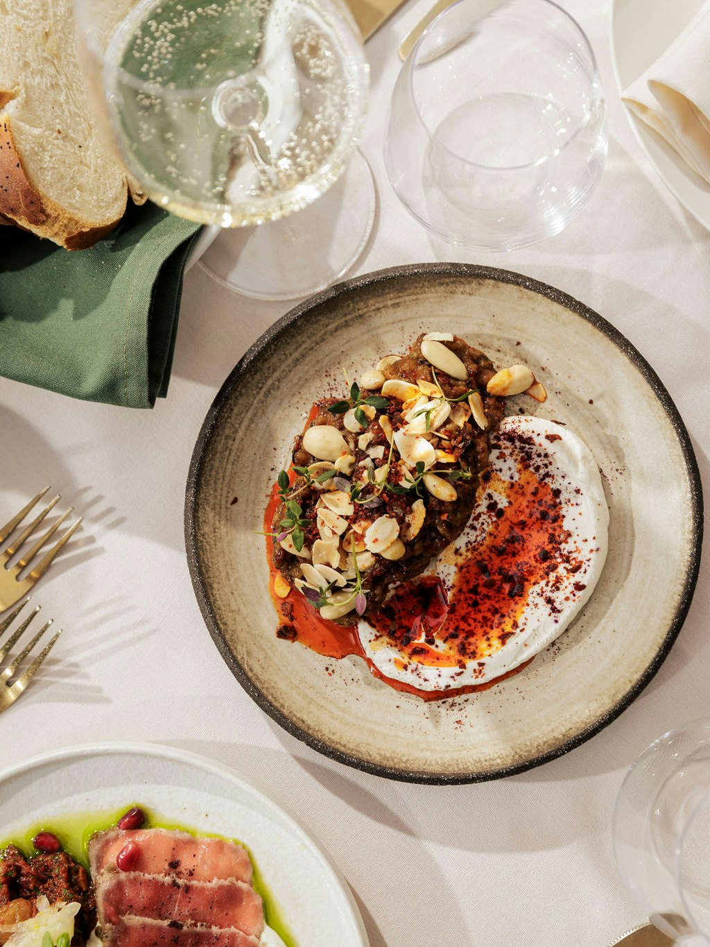 Our smoked aubergine starter brings together warmth, spice and texture, layered with harissa jam, labneh, toasted almonds and Aleppo chilli. A bold, flavour-packed dish that captures the essence of Middle Eastern-inspired dining at The Greenhouses London. 🔥