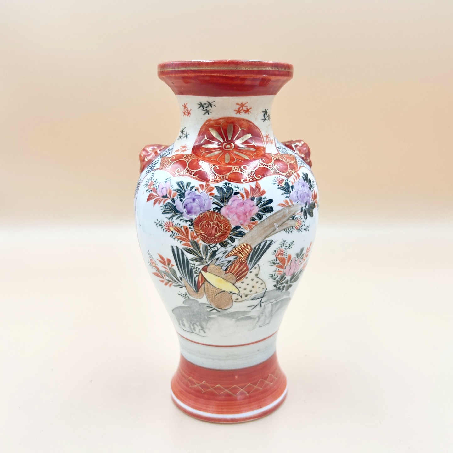 🟢 DOSTĘPNY | Wazon Kutani, lat 1920-40 XX w., Japonia, okres Taisho.
Porcelanowy wazon japoński wykonany w stylu Kutani (Kutani-yaki) z okresu międzywojennego, reprezentujący nurt tzw. Kutani export ware. Forma klasyczna, o lekko rozszerzającym się brzuścu i wąskiej szyjce z rozchylonym wylewem, uzupełniona o niewielkie, reliefowe uchwyty.
Dekoracja została wykonana emaliami naszkliwnymi z dominacją czerwieni żelazowej (aka-e) oraz złocenia, uzupełnionymi różem, fioletem i czernią, co jest charakterystyczne dla palety Kutani.
Kompozycja łączy motywy kwiatowe (chryzantemy, peonie) z elementami figuralnymi i pejzażowymi, zestawionymi w sposób ornamentalny i segmentowy, z wyraźnym konturem i schematyzacją form, typową dla produkcji eksportowej tego okresu.
Wys. 18 cm
280 PLN + 20 PLN koszt wysyłki