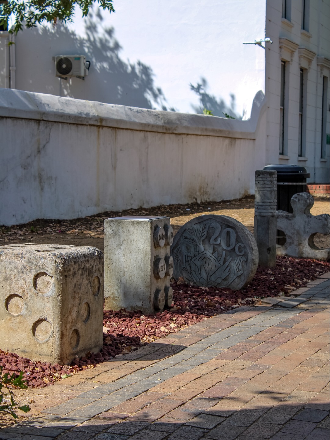 5 THINGS FOUND by Marné Viljoen
2018 | Concrete | 122 Dorp Street (next to Farmer’s Daughter boutique)
“Each concrete shape represents an object that was found while walking through the streets of Stellenbosch. Five Things Found became a way of documenting my days and finding beauty in them. A puzzle piece, a coin, a piece of Lego, a pencil and a dice are beautiful objects for their own sake but also for the stories they tell, even after being transformed into concrete form. There is a magic in their significance and their simplicity. These everyday found objects from these very streets are curated into daily collections, captured on Instagram through a series with the same title.” - @viljoen_marne
Learn more → sost.co.za/artwork/five-things-found
Dreamscapes - Form and space through curious eyes curated by Dr Mike Mavura @mikemavura_ | 26 February 2026 – 30 January 2027
Presented by the Stellenbosch Outdoor Sculpture Trust, @visitstellenboschnow, and proud patron, Private Clients by Old Mutual.
#SOST #Dreamscapes #Stellenbosch #MarneViljoen #WealthCurated