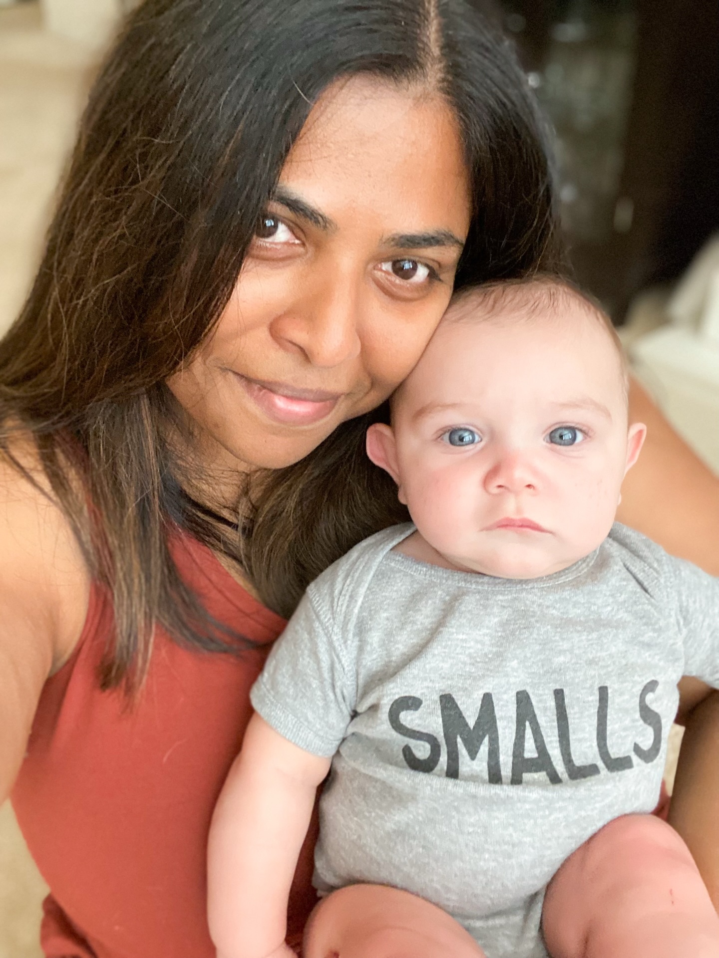 This is my favorite photo of me with my foster son.
He is looking straight into the camera with the most serious face a baby has ever made and I am cheek to cheek with him, completely gone. No studio lighting. No perfect backdrop. Just a selfie on an ordinary day that somehow captured everything.
This is the photo I would hang on a wall.
And then I look at the black and white one. Me on my first birthday. My mother holding me — completely present, completely devoted — and completely turned away from the camera. I am looking straight into the lens. She is looking at me. And nobody thought to say — wait, turn around. Let us see you too.
It was the era of film. Cameras were a luxury. You didn’t take seventeen shots to get one good one. You took what you could and hoped for the best. I understand that. I don’t resent it.
But I miss what we don’t have.
Not the family lineup in front of a tourist sight. Not the group shot at a wedding. Just us. A tender moment. Something I could hang on a wall.
I think about this every time I pick up my camera. Every time a mother sits down with her daughter and they forget for a moment that I’m there. Every time someone looks at the back of the camera and says — oh. Is that really what we look like together?
Yes. That’s exactly what you look like together.
This is why I do what I do with family portraits. This. The in-between moment. The one that becomes the thing you reach for when you need to remember what love looked like on a Tuesday afternoon.
Mother’s Day is May 11th. I’m booking Mom & Me portrait sessions now — for the daughters who want their mothers in the frame. For the mothers who have spent a lifetime behind the camera. For anyone who has looked at an old photo and wished someone had thought to turn around.
