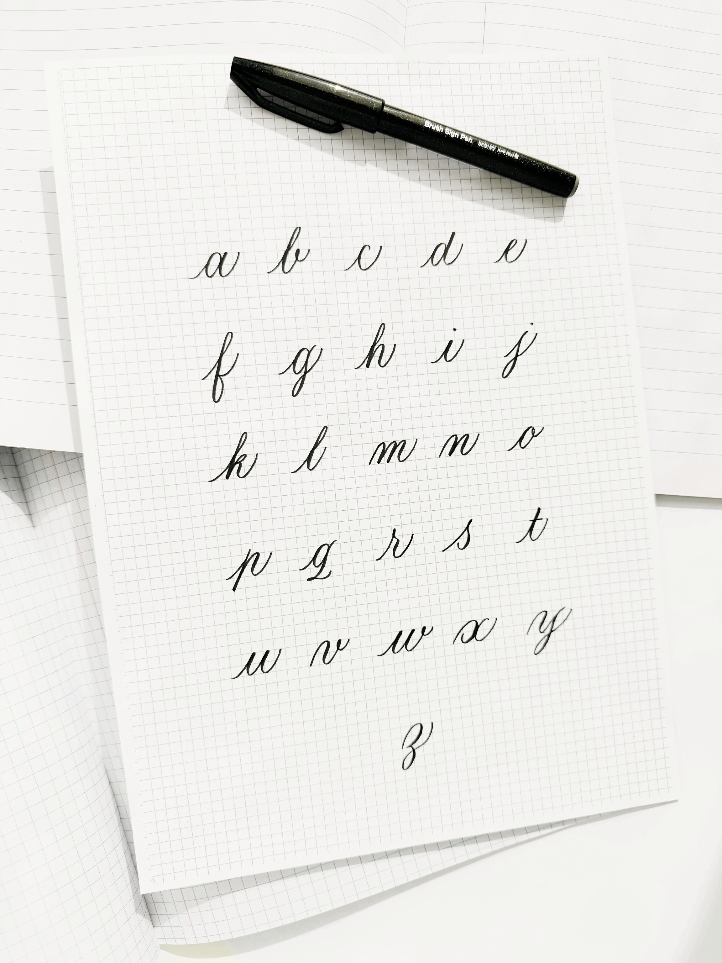 Practicing calligraphy definitely doesn’t have to happen only at your desk at home ✍️
A small brush pen is actually perfect for practicing on the go: pop one into your bag and you can practice anywhere. On a sunny terrace, in your hotel room, or during a quiet moment in between. No messing around with ink pots or accidental spills. Just just take off the cap and start writing. With a brush pen, you can create the same beautiful thick and thin strokes as with a dip pen.
A brush pen is easy to carry and works on almost any type of paper, so you’ll always have the chance to practice a few letters.
One thing to keep in mind: the tip of a brush pen is thicker than the tip of a dip pen. That means your letters naturally need to be a little larger to stay clear and readable.
A helpful guideline: make the waist height of your letters about 5 brush strokes high. If you’re using the Pentel Brush Sign Pen, that usually comes down to about 1 cm in height. This works especially well in a grid notebook, because it gives you an easy reference for keeping your letter proportions consistent.
So: toss a brush pen into your bag and use every spare moment to practice. Those small practice sessions are exactly what make the biggest difference over time 🤓
#brushletteringpractice #brushpencalligraphy #calligraphypractice #calligraphybeginner #calligraphytips