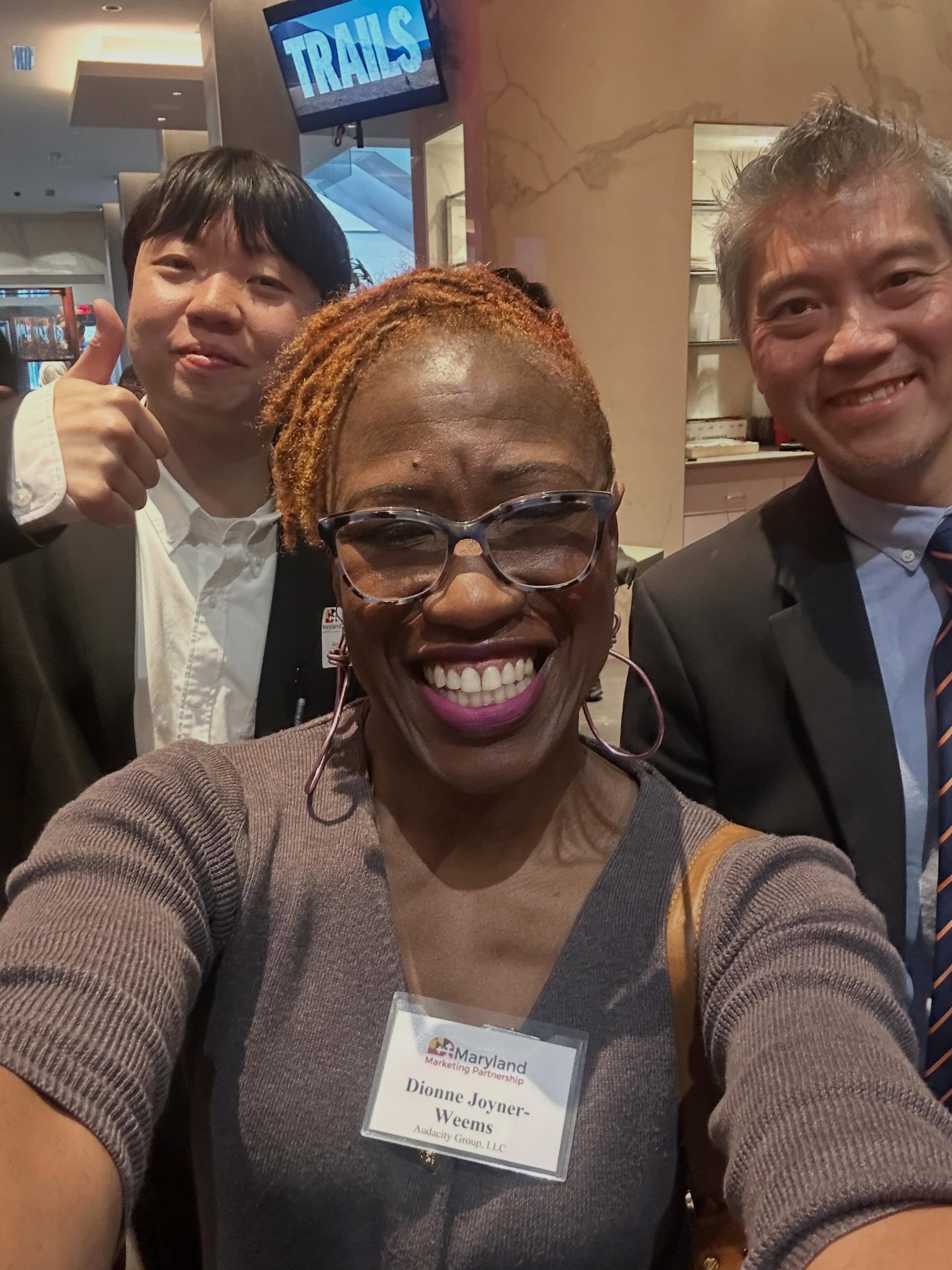 “Hi, my name is Dionne. I’m a board member of the organization hosting this event. Do you mind if I sit with you?”
“Of course.”
“What’s your name?”
“Junghoon Lee.”
And just like that, a conversation began.✨
Junghoon shared that his company develops AI technology designed to protect people from deep fakes, which immediately caught my attention. He told me it was his first time on the East Coast, and I shared how much I admire South Korean culture — the food, the fashion…
He interrupted me smiling:
“And our K-dramas.”😊
I laughed immediately because he was absolutely right.🫣🙌🏾
And somehow, in the middle of an international business event, the conversation shifted from technology and trade to grief, humanity, and healing.
I shared with him that since my father’s unexpected passing last year, Korean dramas on Netflix have brought a sense of peace to my mother. The colors. The soundtracks. The emotional arcs. The softness of the endings. In a season of grief, they became an unexpected comfort.
He offered his condolences.
And I gave him a hug.🫶🏾
Different countries.
Different backgrounds.
Different lived experiences.
Yet for a moment, none of that mattered more than our shared humanity.
That interaction stayed with me.
#SelectUSA
#throwbackthursday
#GlobalConnection
#DionneJoynerWeems
#mybmore