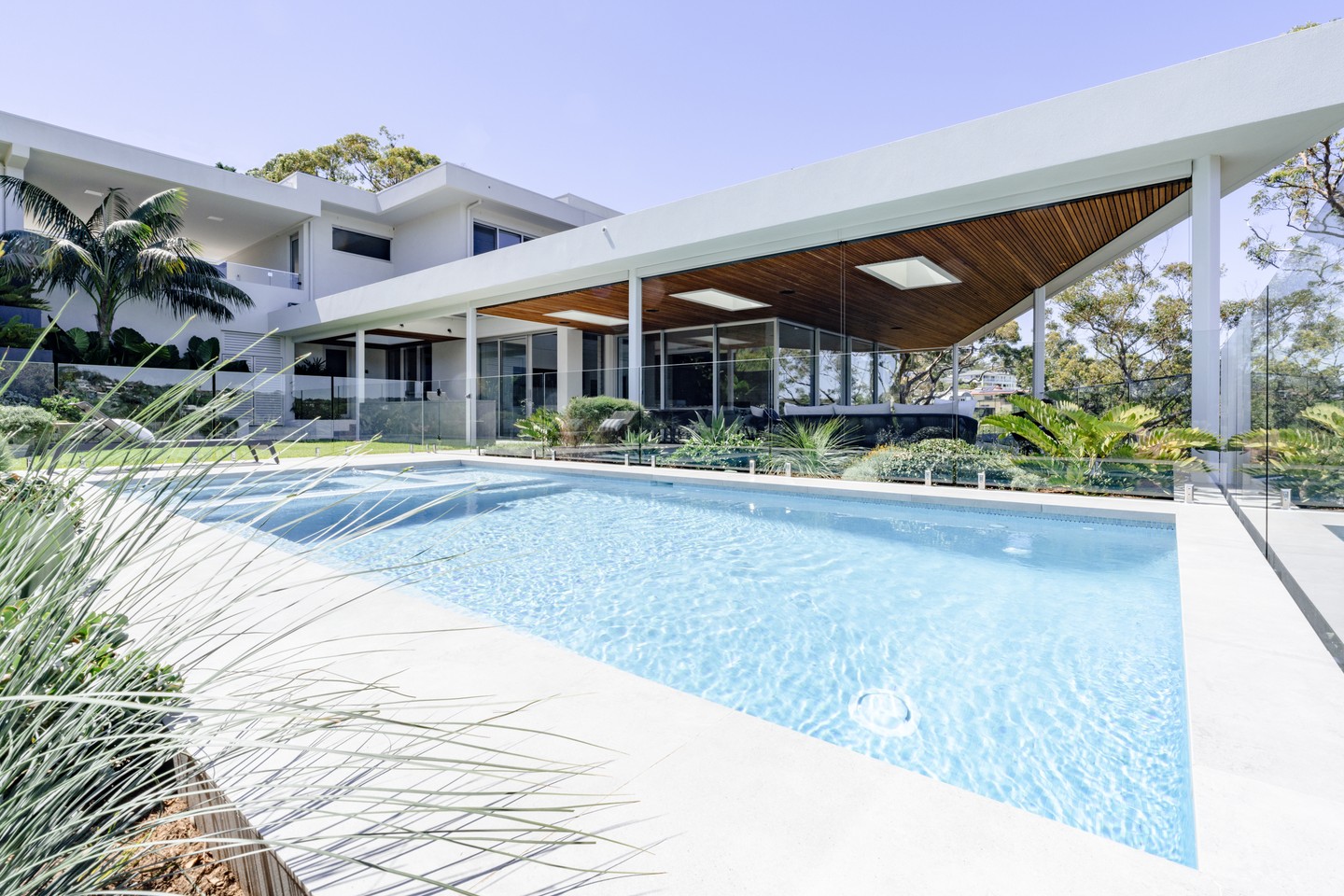 Sharp lines of the pool matching beautifully with the sharp, architectural lines of this stunning new home in Yowie Bay.
This was an exciting project in conjunction with a luxury custom home build set on a steep escarpment overlooking the river. We worked in lock-step with the home builder to ensure a seamless flow between the pool and home creating the ultimate outdoor living paradise.