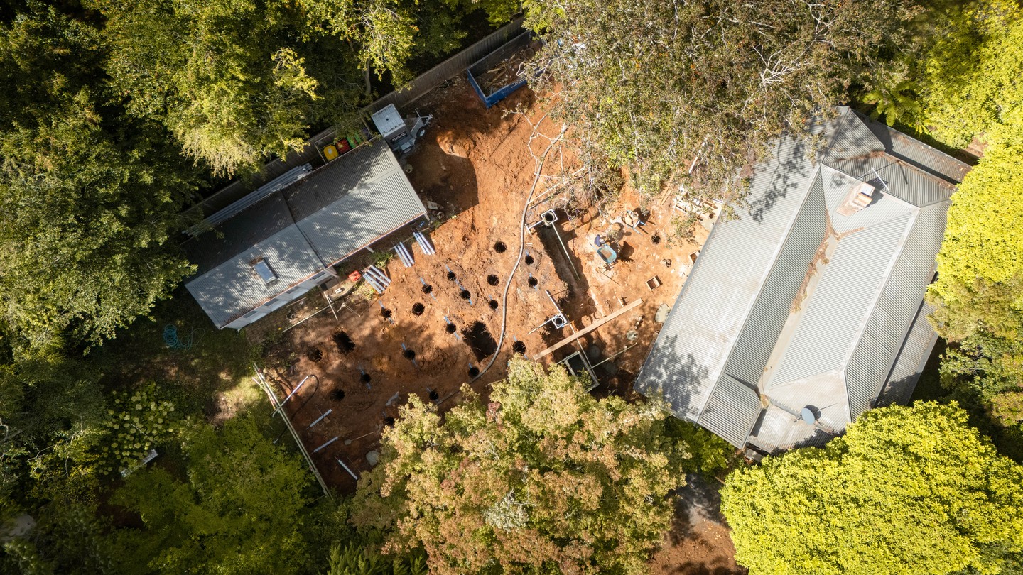 The pier footing pour at Mount Macedon - from above you can see the full footprint laid out across a red clay site hemmed in by established trees on all sides. On the ground it's tight, coordinated work, with each footing hand-finished and set to level before the subfloor frame can follow.
#buildtrendhomes #macedonrangesbuilder #mountmacedon #newbuild #siteprogress