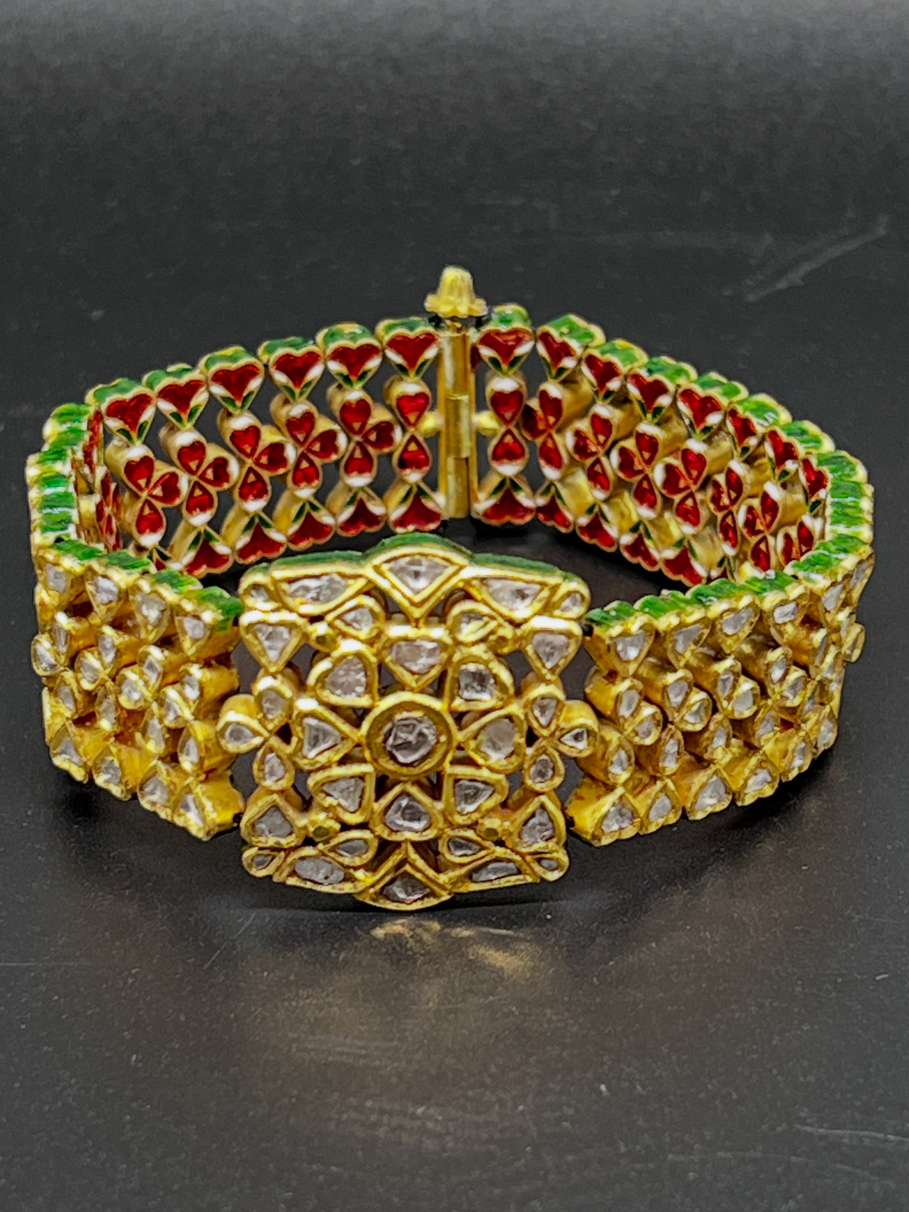 remarkable Indian Polki bracelet crafted in 20k yellow gold, set with 191 rose-cut natural diamonds and finished with vivid hand-applied enamel decoration.
The reverse reveals intricate red, white, and green enamel work — a beautiful detail reflecting the artistry behind the piece.
Bold, sculptural, and richly textured, this bracelet carries the unmistakable character of traditional Indian jewellery design.
Available for private viewing by appointment only.