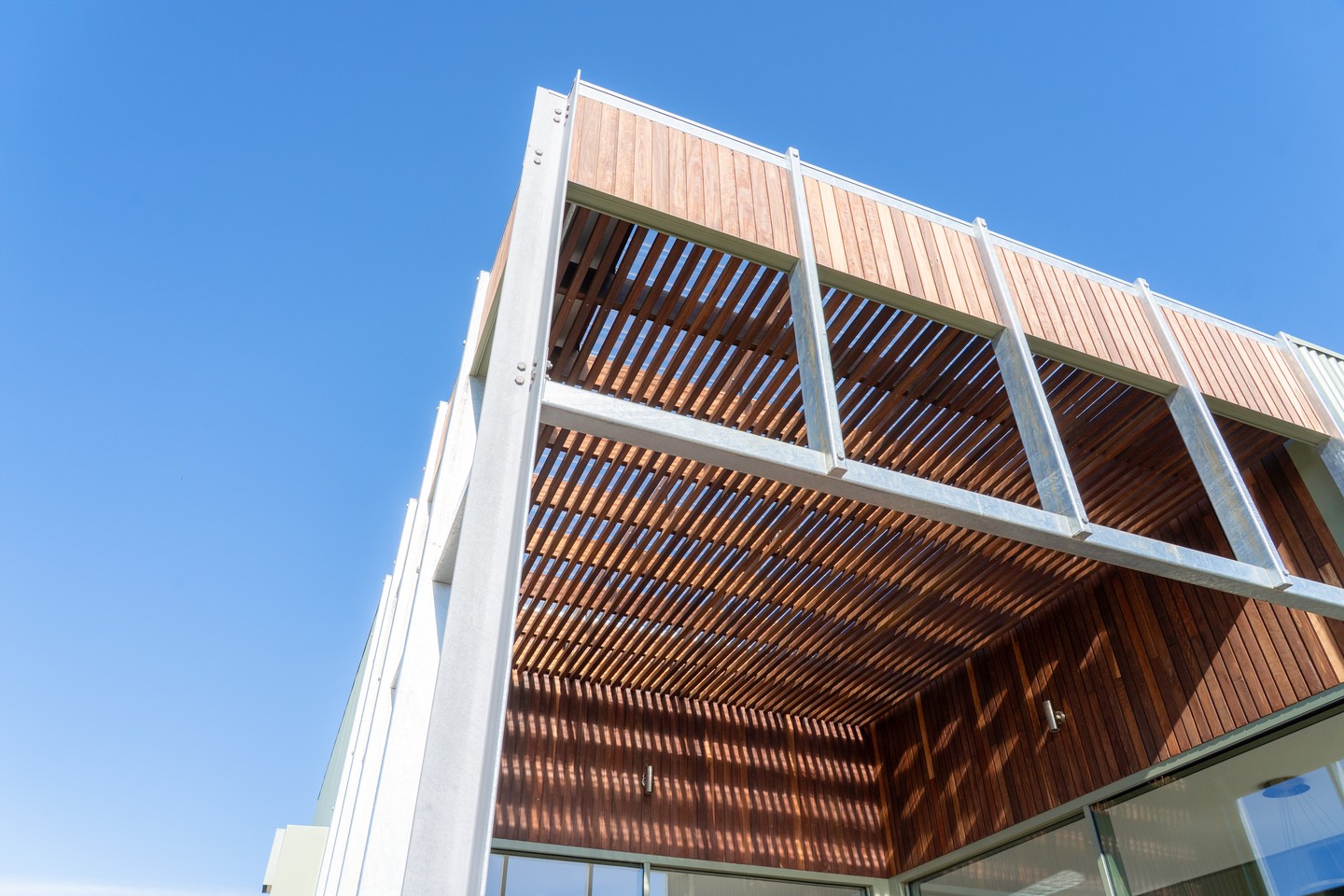 Hardwood battens set within a galvanised steel frame - a pergola cover that filters light, adds warmth to the facade, and holds up to the elements. The spacing and shadow pattern is as much a design decision as a practical one.
#buildtrendhomes #macedonrangesbuilder #custombuilder #pergola #architecturalbuild