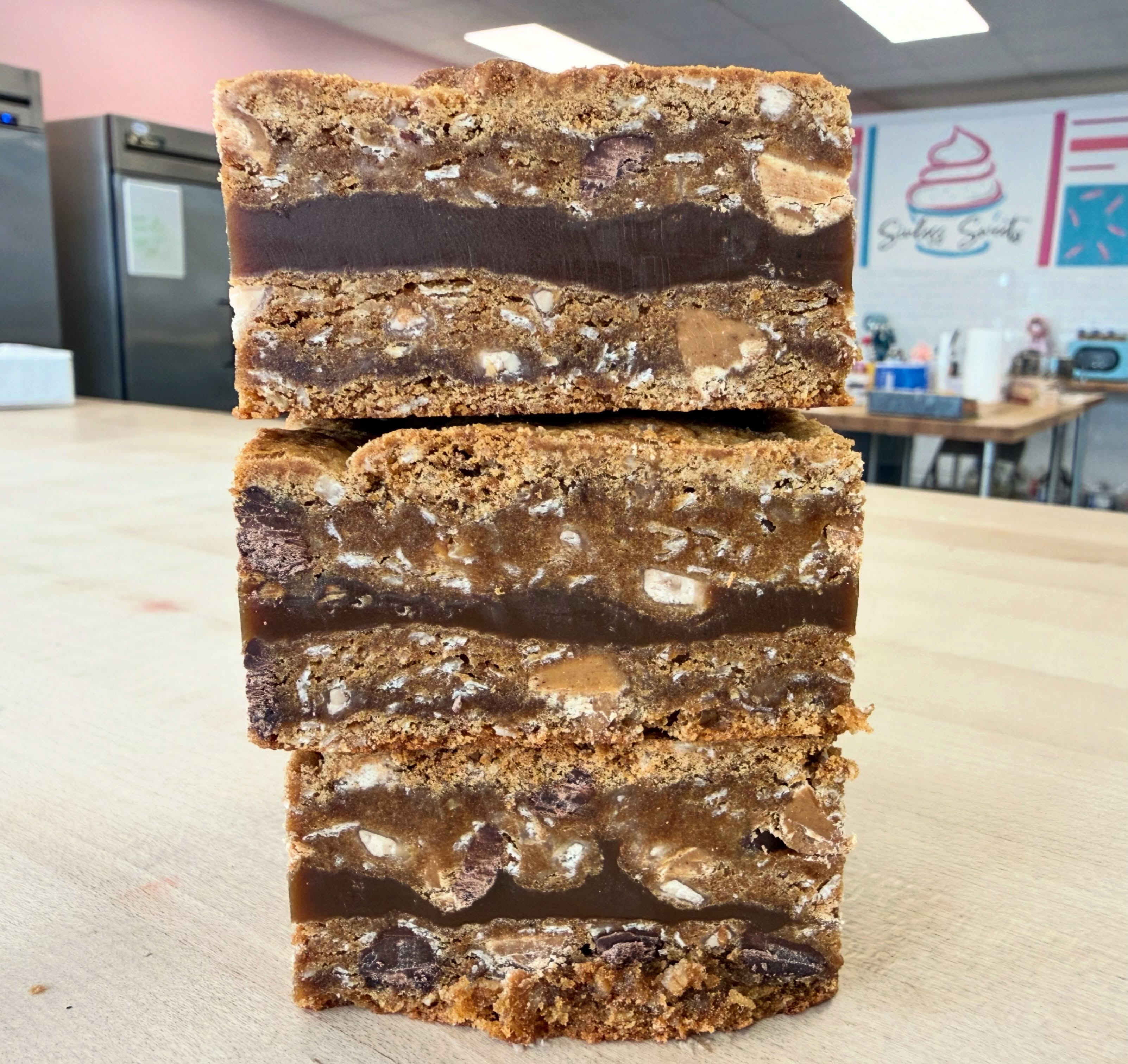 NEW DESSERT DROP at the bakery today!! 🤩🍪
Y’all… we are rolling out our BRAND NEW MENU this week and we seriously can’t wait for you to try everything!!
One of today’s featured desserts is our PB CARAMEL TOFFEE CHOCOLATE CHIP COOKIE BAR!! 😍
And yes… it tastes just as good as it sounds 🤤
We combined all your favorite flavors into one rich, gooey, chocolatey dessert bar loaded with peanut butter, caramel, toffee, and chocolate chips!!
The BEST part? It’s completely GLUTEN FREE!! 🙌✨
These bars are soft, decadent, packed with flavor, and guaranteed to satisfy every sweet tooth 🍫
NOW AVAILABLE in our showcase today — come grab one before they’re gone!! 🏃♀️💨