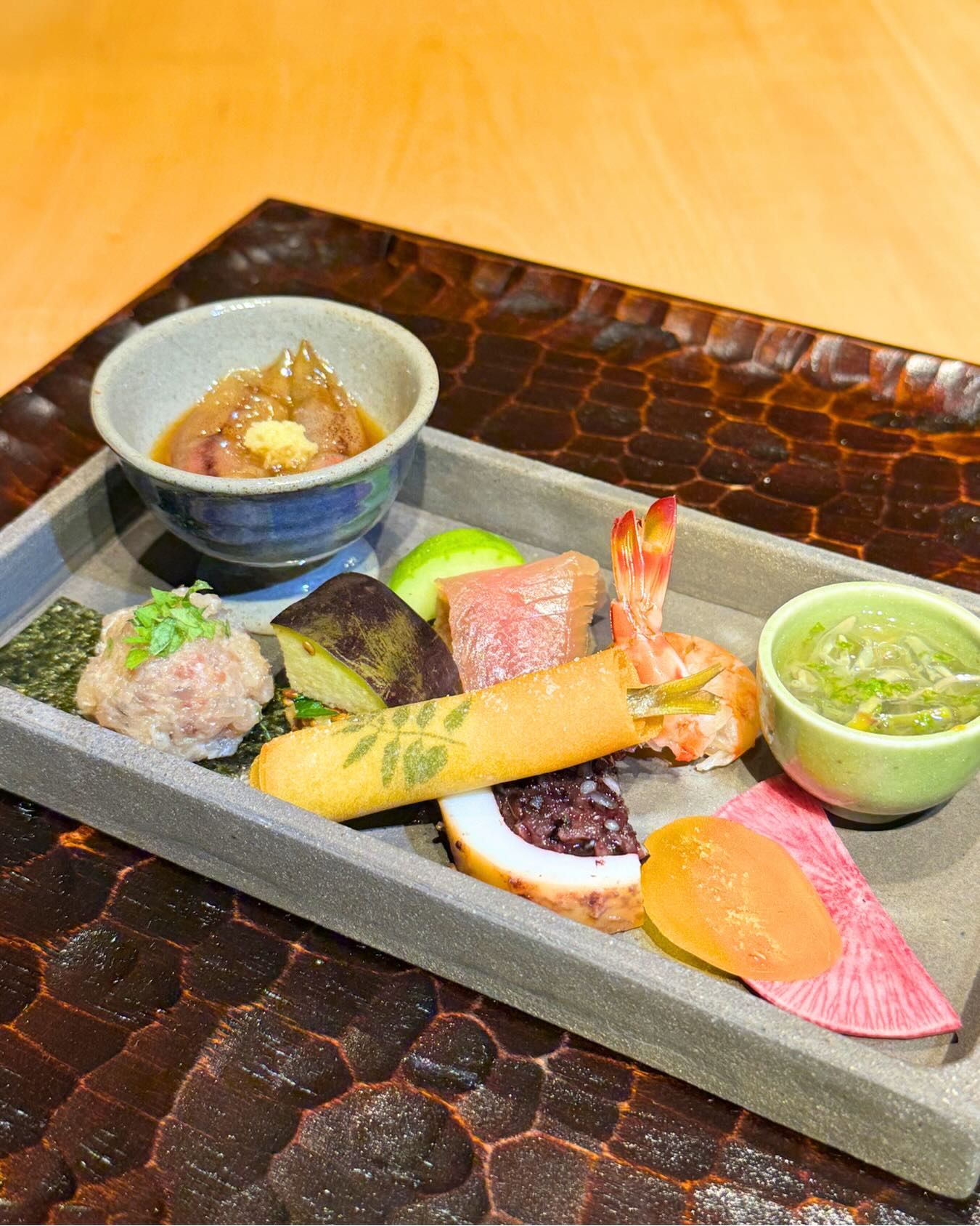 【五月 旬菜盛合せ】
季節の味覚を少しずつ重ねた、旬菜盛合せ。
蛍烏賊の醤油漬け、
白瓜の辛子漬け、
鰹の生ハム。
車海老のいしり漬け、
じゅんさい酢には青柚子を削って爽やかに。
真鯵のなめろう、
大葉を添えた水茄子の浅漬け、
稚鮎と木の芽の春巻き。
さらに、黒米ともち米を鋳込んだヤリイカ、
自家製唐墨を合わせた唐墨大根まで。
一品ごとに異なる香り、食感、余韻。
旬の素材を少しずつ味わいながら、
季節の移ろいをお楽しみいただける盛合せに仕立てました。
お酒とともにゆっくりと味わっていただきたい、
和史らしい一皿です。
_______________________
あかさか 割烹 和史
@akasaka_kappou_washi
所在地:東京都港区赤坂3-13-6 国際天野ビル6F
アクセス:千代田線赤坂駅1番