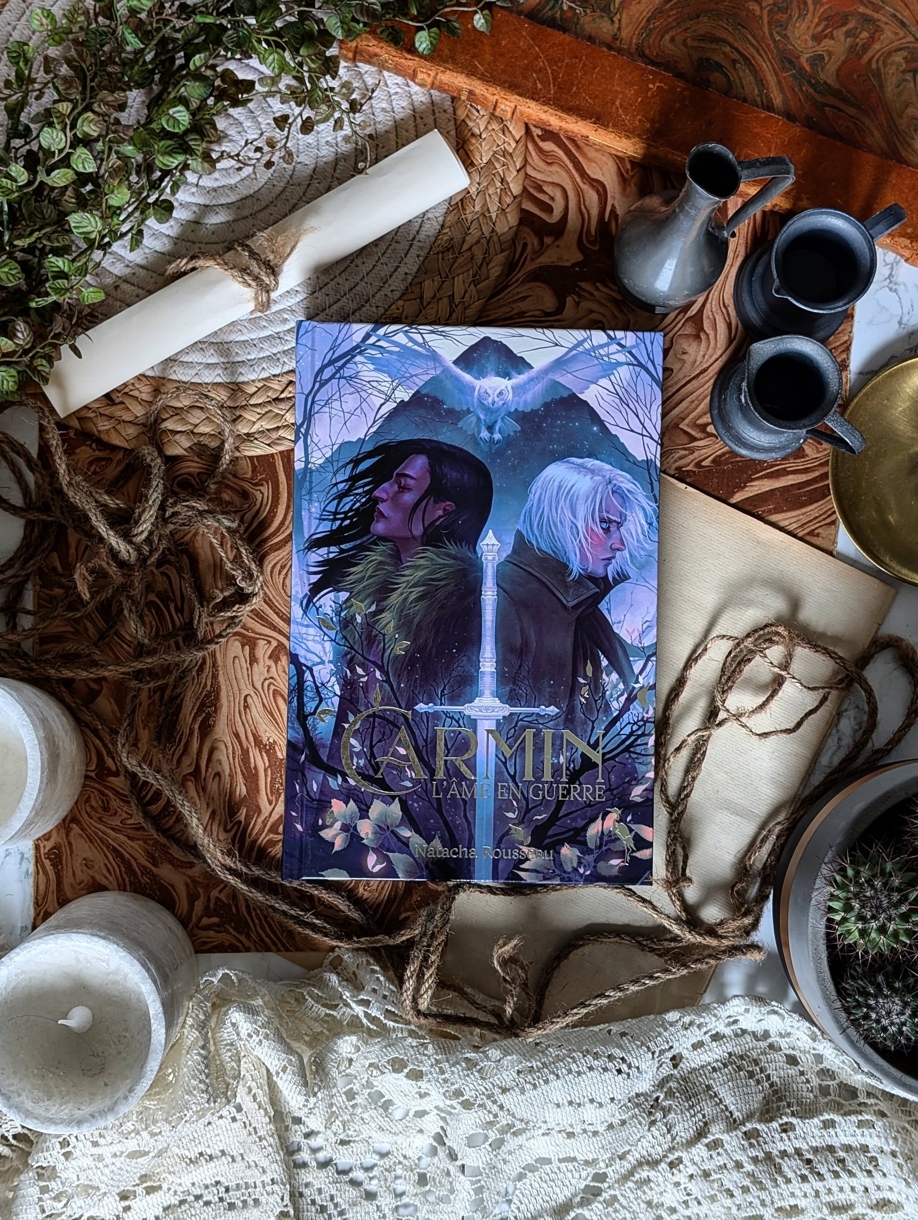 ✨ Carmin : L’âme en guerre - Natacha Rousseau ✨
Cap sur le folklore chamanique avec cette fantasy originale.
Sur ces terres, les esprits accompagnent les hommes au quotidien. Ils vivent à leurs côtés et les guident… et c’est dans ce contexte que l’on découvre Latéus, destiné à devenir le futur shaman de sa tribu.
Mais pour achever sa formation, il doit partir sur l’île maudite de Morgrev. Un endroit qui porte particulièrement bien son nom puisque les esprits y disparaissent… et que les hommes n’en reviennent jamais.
C'est là bas qu'il va rencontrer Carmin, son seul guide, qui est aussi son exact opposé. Alors que l'optimisme de l'un rencontre le pessimisme de l'autre, les deux nouveaux compagnons vont parcourir cette île maudite...
Mais sortiront-ils tout a fait les mêmes de cet endroit ?
J’ai adoré découvrir ces deux protagonistes si différents et voir leur relation évoluer au fil des pages. Plus l’histoire avance, plus on comprend la profondeur de leurs blessures et la manière dont leurs personnalités se complètent malgré leurs différences. Les voir se chercher, s’apprivoiser et apprendre à se faire confiance était un vrai plaisir.
Le lore est très fourni, ce qui est une bonne chose car ce genre d'univers laisse tellement de place à l'imagination. Tout ce qui tourne autour du shamanisme, des esprits et de cette dualité permanente entre la vie et la mort est hyper intrigant et nous suit tout le long de l'aventure. On y trouve aussi des traditions, des détails sur les cultures... C'est très complet !
Je dois dire que j'ai aussi beaucoup aimé la plume qui passe par pas mal d'émotions différentes, c'est une très bonne surprise.
En bref, c’est une histoire originale avec des personnages attachants et marquants. Si vous aimez les aventures qui vous chamboulent, foncez le découvrir chez @editionsleherondargent !
#review #Booklover #BookstagramMeute #carmin #herondargent