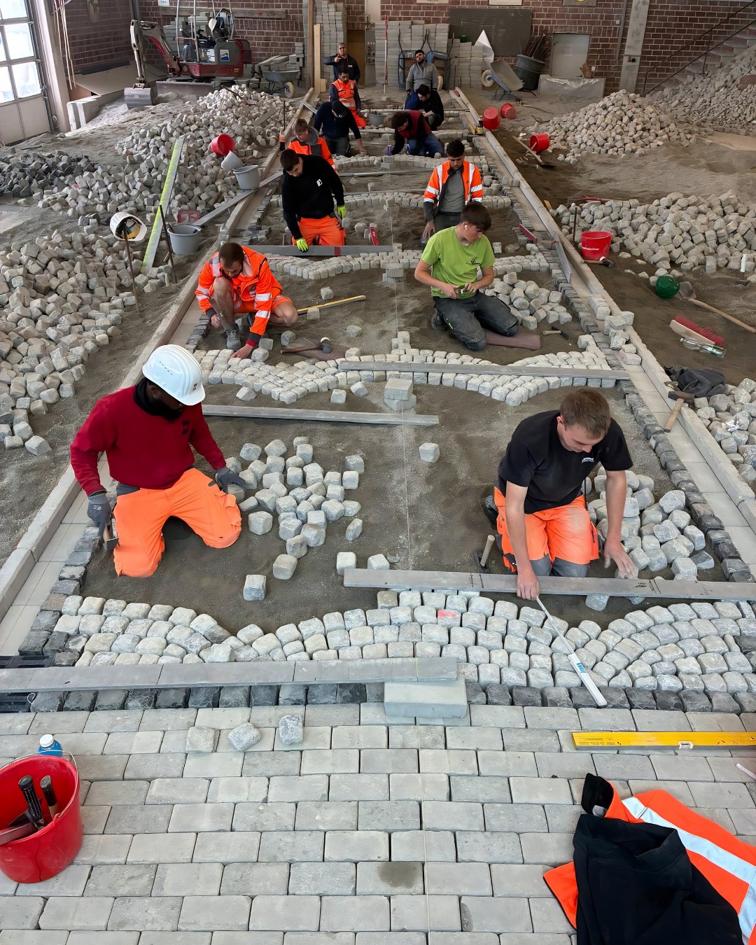 🚧 Stein an Stein – die Straße wird bald fertig sein!🚀
Für unsere Straßenbauer-Azubis im 2. Lehrjahr stehen aktuell Pflasterarbeiten auf dem Programm. Ziel ist die Herstellung einer fertigen Fahrbahnoberfläche mit Segmentbogenpflaster. 🛣️📐
Neben der fachpraktischen Ausführung stehen außerdem Arbeitssicherheit, ergonomisches Arbeiten, Qualitätsmanagement sowie der sachgerechte Umgang mit Werkzeugen und Maschinen im Mittelpunkt der Ausbildung. 💪👷♀️👷♂️
So entsteht aus vielen einzelnen Steinen Schritt für Schritt eine hochwertige und belastbare Pflasterfläche im BZ Bau Geradstetten. ➡️🛣️
#Pflasterbau #Naturstein #Segmentbogenpflaster #Straßenbau #Geradstetten #Bauen4NextGen