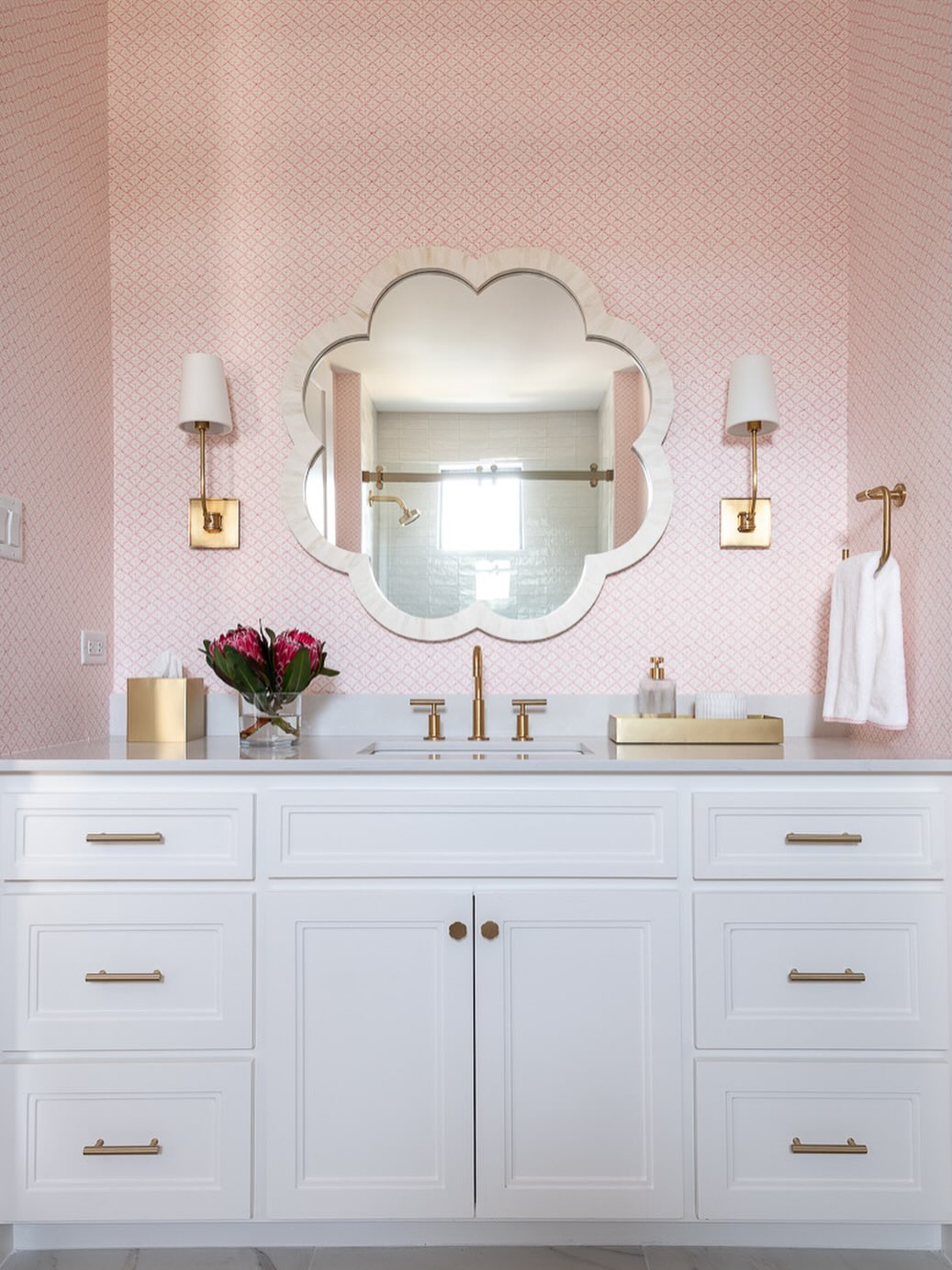 Pretty in pink 💕✨ A soft blush backdrop, gold accents, and a statement mirror turn this vanity into a dreamy retreat.