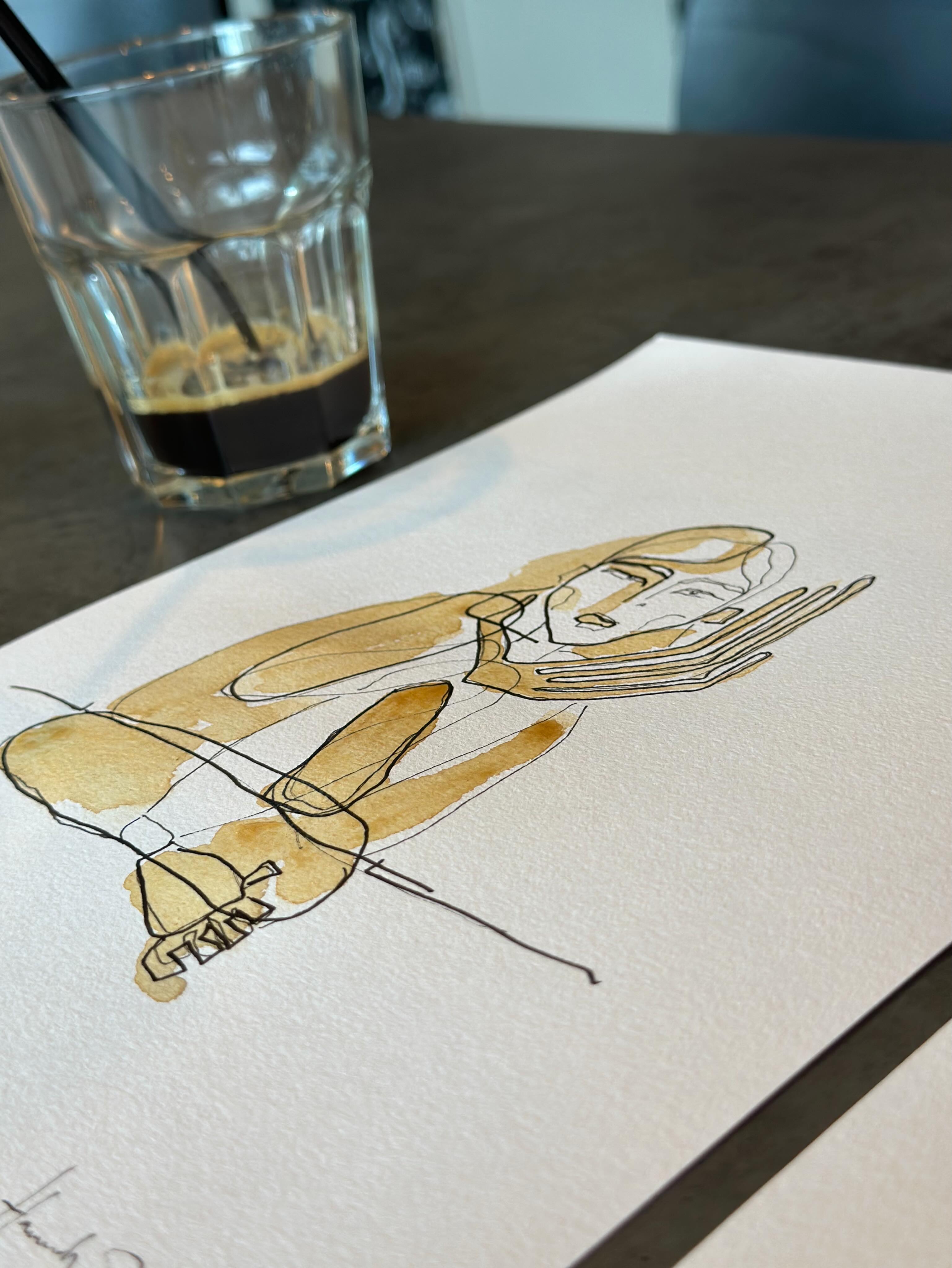 Black, fast lines, just enough to suggest a person, a presence, a passing moment.
Ever since high school, sketching has been my way of capturing strangers, energy, movement.
And coffee somehow always finds its way into the work too.
A drink I genuinely love, but also a medium that travels with me everywhere, staining the paper with the warmth, imperfection and depth a drawing sometimes quietly asks for. ☕️✍🏼