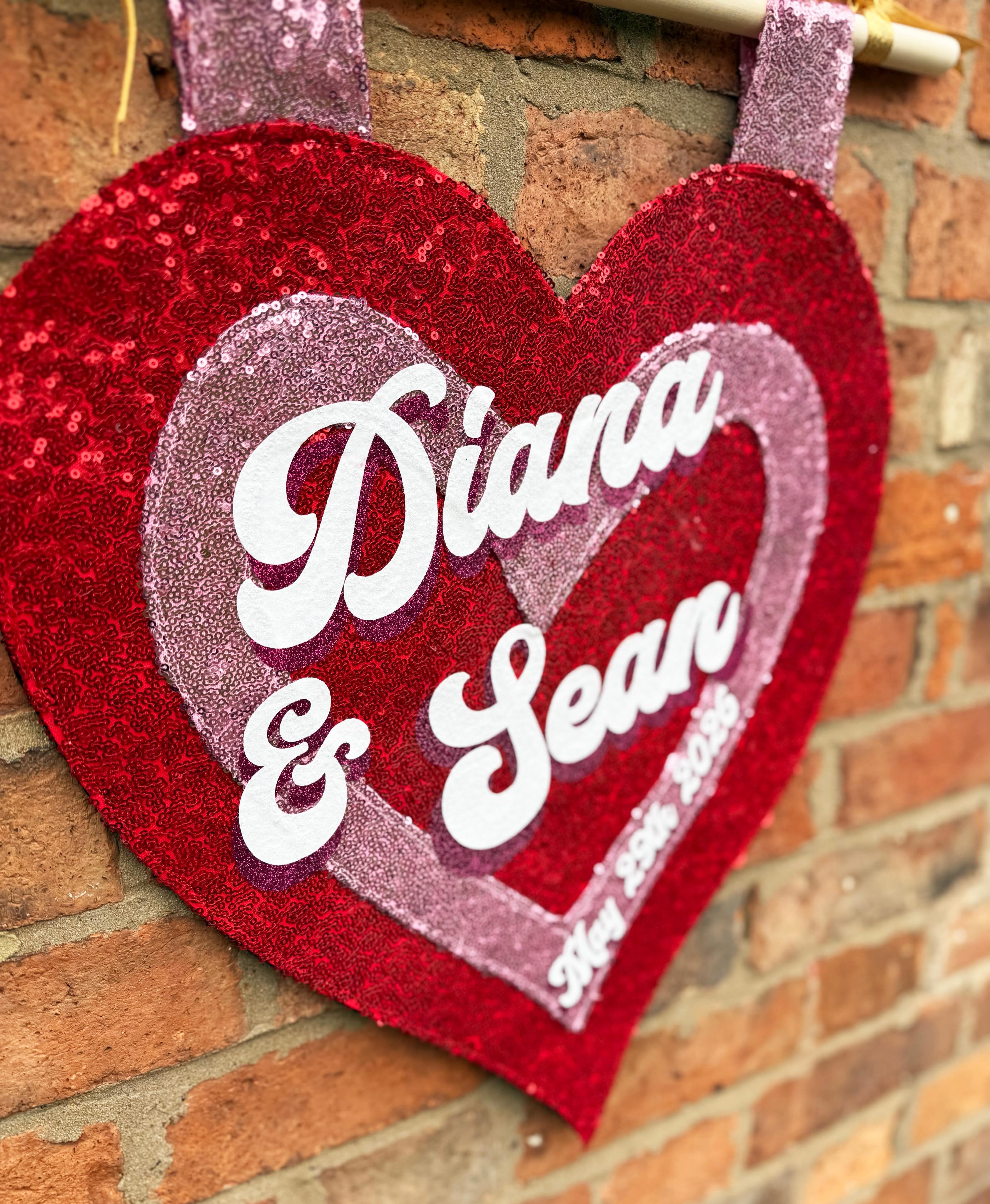“I’m over the moon with how my sign came out! Literally photos don’t even capture how beautiful and well crafted the signs are! 100% recommend.”
Thank you Diana. I’m so pleased your big day has finally arrived seeing as you ordered this at the beginning of last year 🥂. You must be so excited.
Congratulations to you both and have the best day! ❤️
Custom name pink and red sequin heart shaped wall hanging for Diana and Sean’s wedding on the 29.05.26.