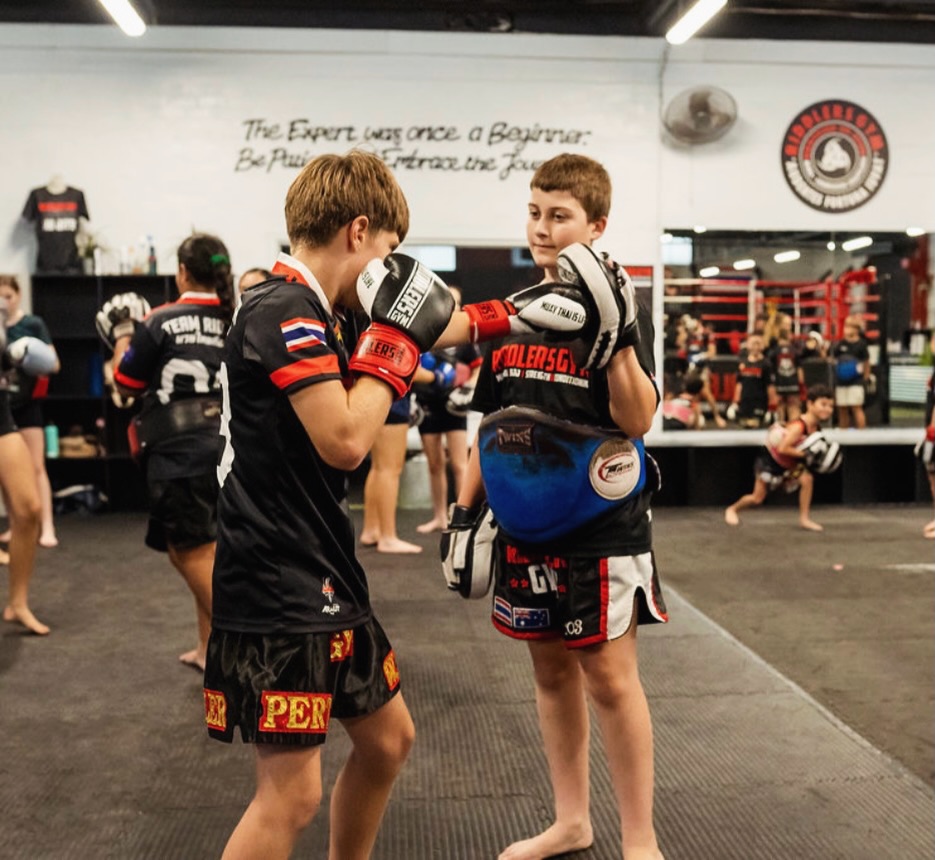 🥊 KIDS MUAYTHAI 🥊
Build Confidence • Discipline • Fitness • Respect
Our classes help kids develop effective Muaythai skills, control, strength and discipline whilst building confidence, making friendships and learning to challenge themselves both physically and mentally — all while having fun! 💥
Classes Available For:
👊 Ages 4–7yrs
👊 Ages 8–12yrs
👊 Teens 13–16yrs
✅ 4 Days A Week Training Opportunities
✅ Fun, Safe & Supportive Environment
🌟 FUTURE CHAMPS PROGRAM 🌟
Our advanced youth development program for dedicated students wanting to take their training to the next level.
Invitation Only
Start your child in Muaythai today!
🔥 FIRST CLASS FREE 🔥