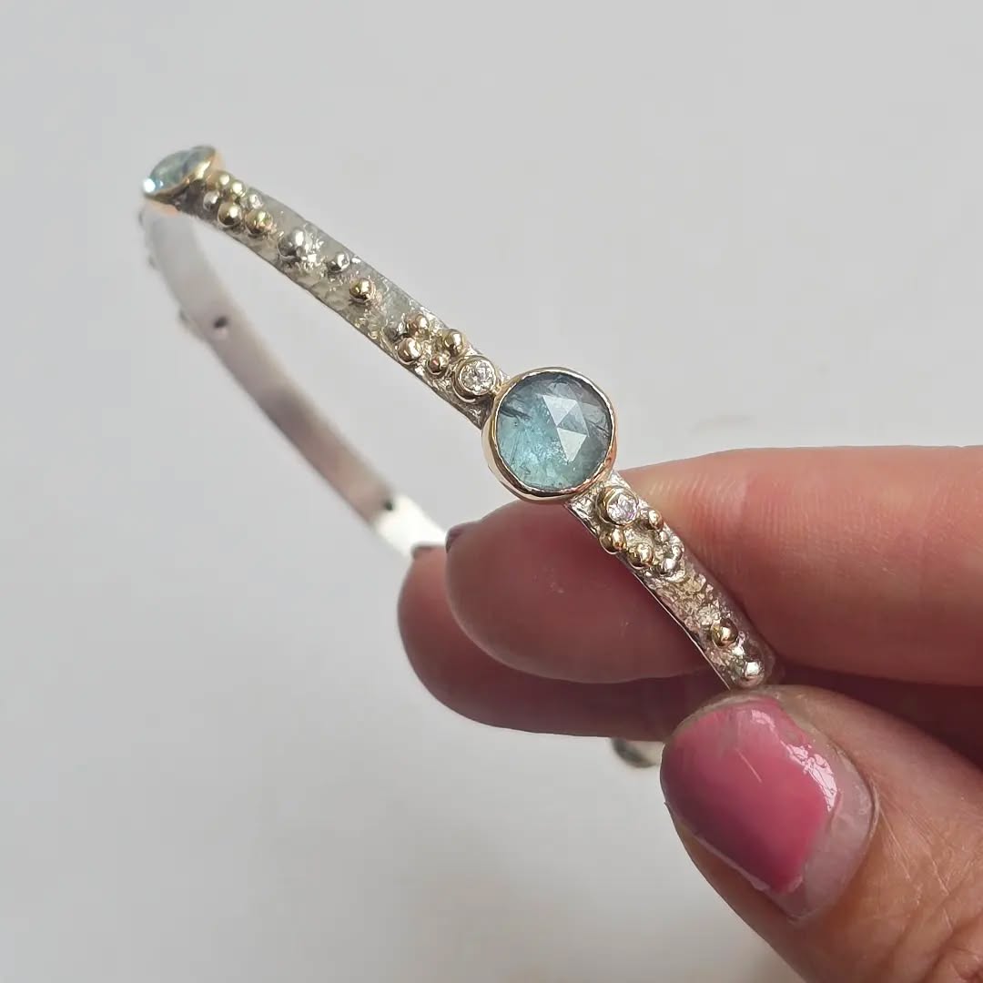 I made this bangle for my customer using her old gemstones from rings she didn't wear anymore. I melted down her old 9ct gold ring for the little granulation balls.
This bangle was a real labor of love and definitely tested my patience as a jeweler! It's silver with 9ct gold settings and granulation.
My customer was amazing and super patient while waiting for it, so thank you! ✨️