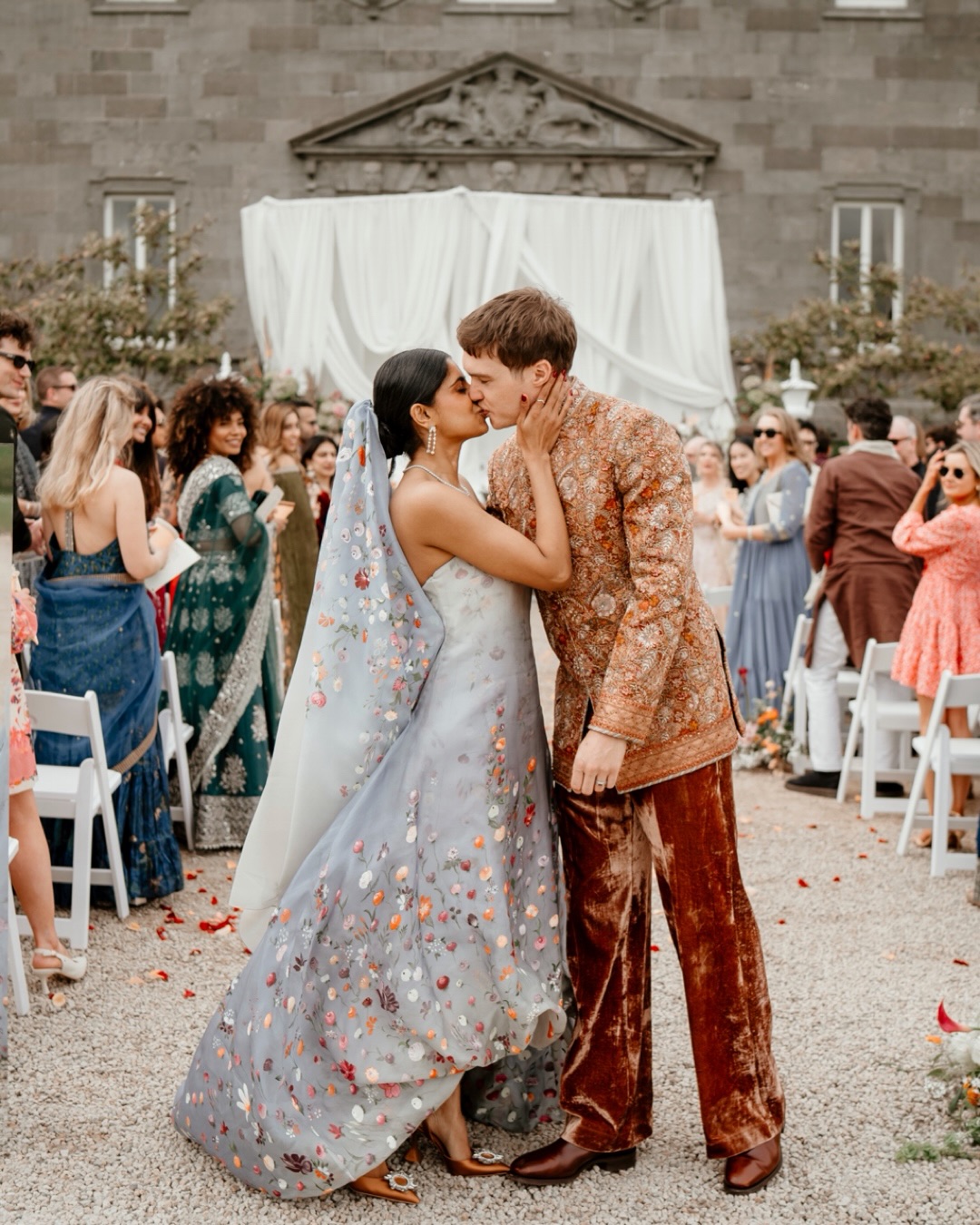 There was so much intention woven through this entire day. Not just in how it’s appearance, but in what it meant.
An Irish and Indian wedding built from symbols, gestures, family history and future memory. Calla lilies passed between hands during the ceremony. Rings warmed by every guest before being exchanged. Vows sealed away with a bottle of wine for their future selves to one day reopen. A dress hand-painted by the bride’s great Aunt and Mother, with a small clover as a nod to Ireland. A surprise fireworks display. A baraat that shook the ground. Irish wolfhounds wandering the gardens like something from folklore.
It felt less like watching traditions side by side, and more like watching two histories slowly fold into one another.
These are the weddings I am most drawn to.
The ones where meaning exists everywhere. In clothing, movement, sound, family, objects, ritual, atmosphere. The kinds of days where photography becomes less about simply documenting events, and more about preserving evidence of people, heritage and feeling.
An archive of not just how it looked.
But what mattered.
