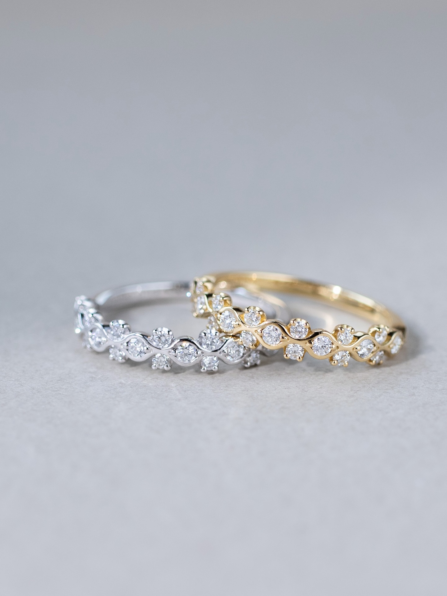 The Ivy Diamond Band Ring traces gentle curves inspired by the climbing patterns of ivy flowers — delicate, flowing lines crafted in gold, wrapping softly around brilliant-cut diamonds.
Rather than a traditional straight band, the design moves with an organic rhythm, as though the diamonds are quietly woven into the vines themselves. Light, elegant, and easy to layer, it is a ring that adds a subtle sense of movement to the hand.
A modern diamond band with a softer, more natural expression.
Discover the Ivy collection at FUJIMORI KAJITA.