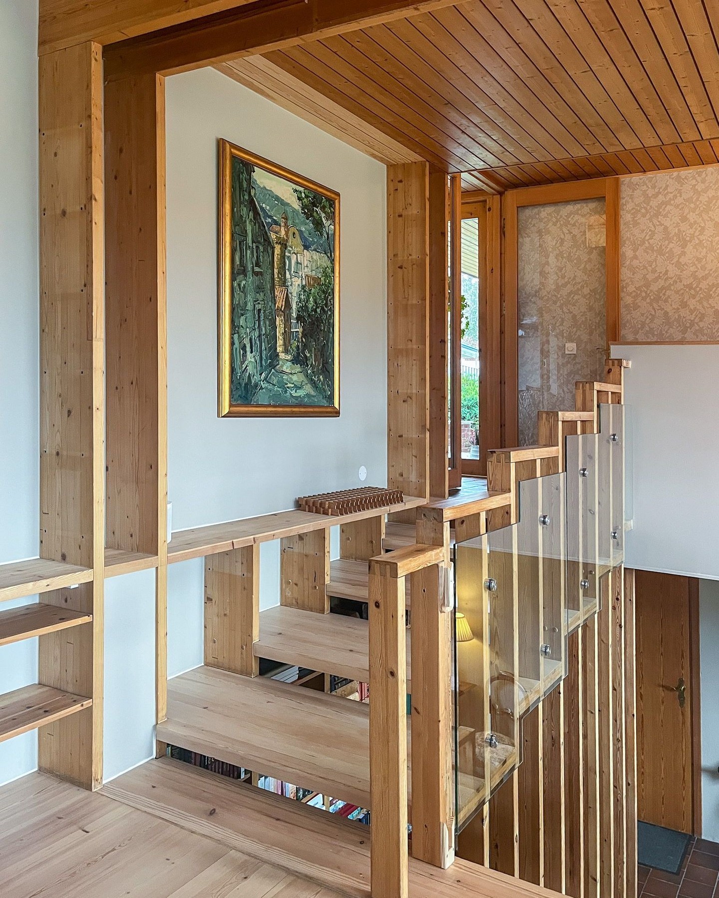 Det er alltid så utrolig hyggelig når tidligere kunder kommer tilbake for et nytt prosjekt! Her har kundene kjøpt nytt hus, og dette huset er virkelig spesielt. Det er godt ivaretatt, tidstypisk og med mange elementer kundene ønsket å la stå. Det er en annen måte å tilnærme seg et slikt prosjekt på fordi det er en del man må ta hensyn til, det er ikke et blankt ark, men det er også veldig gøy.
Dette er bilde fra stuen som ligger på et nivå mellom to etasjer. Deler av de originale hyllene er fjernet men rekkverk og hovedlinjene er beholdt, noe som er et tydelig designgrep fra huset var nytt. Resultatet ble veldig bra 😀