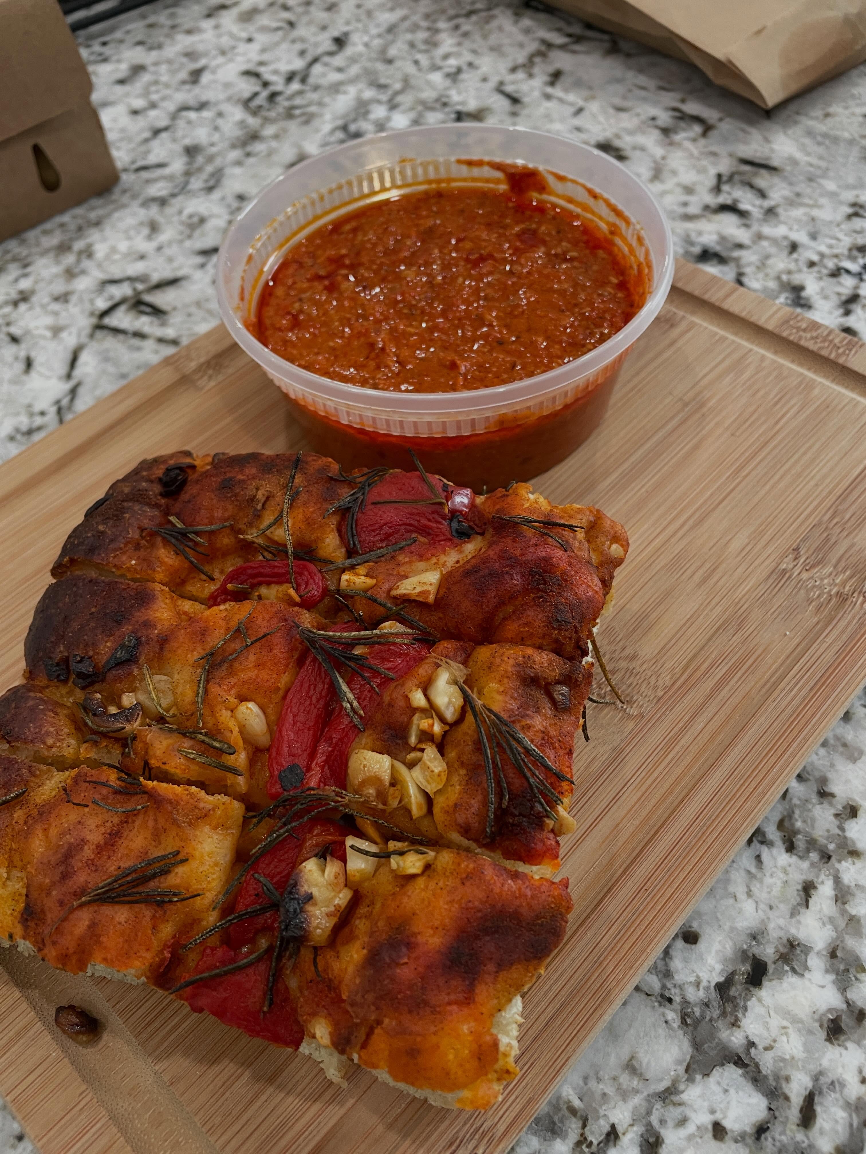Sunday Dinner, Spanish Style…
Sunday dinner was simple this week.
In Spain, Romesco is spread on bread, spooned onto eggs at breakfast, and served alongside grilled chicken and fish.
Roasted is my take on that traditional Spanish roasted red pepper spread.
After Saturday at Empire Market, you were gracious enough to leave me a 4x5-inch piece of Spanish Focaccia and a container of Roasted.
I popped the focaccia into a 350° oven for about 12 minutes.
Since I didn’t want the rosemary to burn, I tore off a sheet of parchment paper, crumpled it into a ball, then stretched it back out and laid it over the bread.
The wrinkles helped it stay put without blowing off while the focaccia warmed. (Old habits from baking in commercial convection ovens die hard.)
When it came out of the oven, I sliced it into sticks and dipped away.
Sometimes that’s all you need.
Pre-order Spanish Focaccia and Roasted online (link in the first comment).
📍 Carl Junction Farmers Market • Thursday 4–7
📍 @joplinempiremarket • Saturday 10–2
Follow @purplechincondiments for market updates.
💜 Made by hand. Bottled with attitude. Powered by farms.