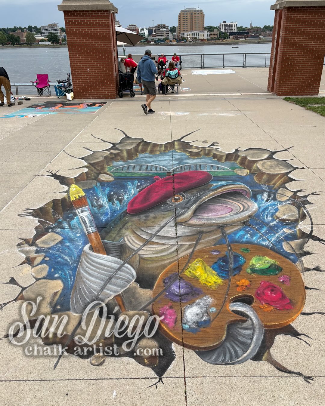 Got to chalk this bad boy at Quad City’s 10th annual Chalk Art Fest- I was the featured artist and a guest judge for their chalk art competition!
“Catfish Charlie” - Original 3d design created for QCA: A Catfish from the Mississippi River is busting out of the ground and ready to make some art. Centennial Bridge is in the background.
20’ tall x 12’ wide - 19 hours start to finish
Sadly, the rain came shortly after completion, so here’s pics so you can see what happens when it rains! We try to cover it up and save it, but sometimes the rain is too heavy and water seeps under and does damage… but people still enjoyed looking at it when the storm passed!
I want to thank Quad City Arts @quadcityarts for hosting me and putting this all together, The Figge Art Museum @figgeartmuseum for letting me do a talk about chalk art, and The Cultural Trust @theculturaltrustqc for their time and efforts in elevating the arts in this region. Thank you to Austin who jumped in on Sunday to help me finish on time and to fix water damage made to the piece.
QC is about two and a half hours west of Chicago and is on the border between Illinois and Iowa, separated by the Mississippi River (which has a lot of catfish in it!). This is a fantastic chalk fest and there’s a lot of local talent! Photos of some of the winning chalk art pieces at the end of the carousel.
#QuadCityArts #QuadCityChalkArtFest #3dChalkArt #SanDiegoChalkArtist #AtlantaChalkArtist