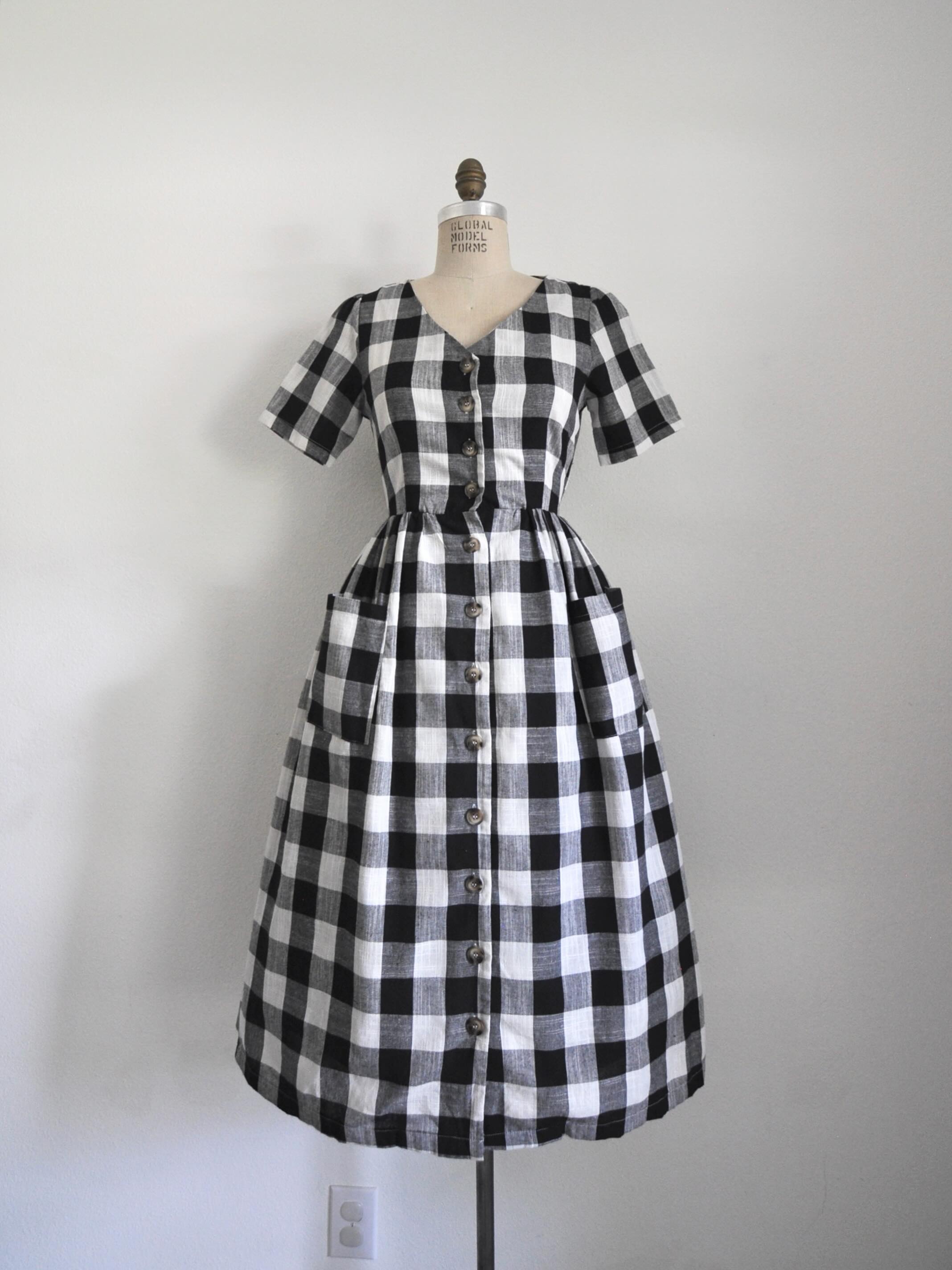 Link in bio to shop! Black and white plaid dress. Linen blend, functional buttons, fitted waist, patch pockets. Bust: 35” Waist: 28” Length: 46” Shoulder to waist: 15”