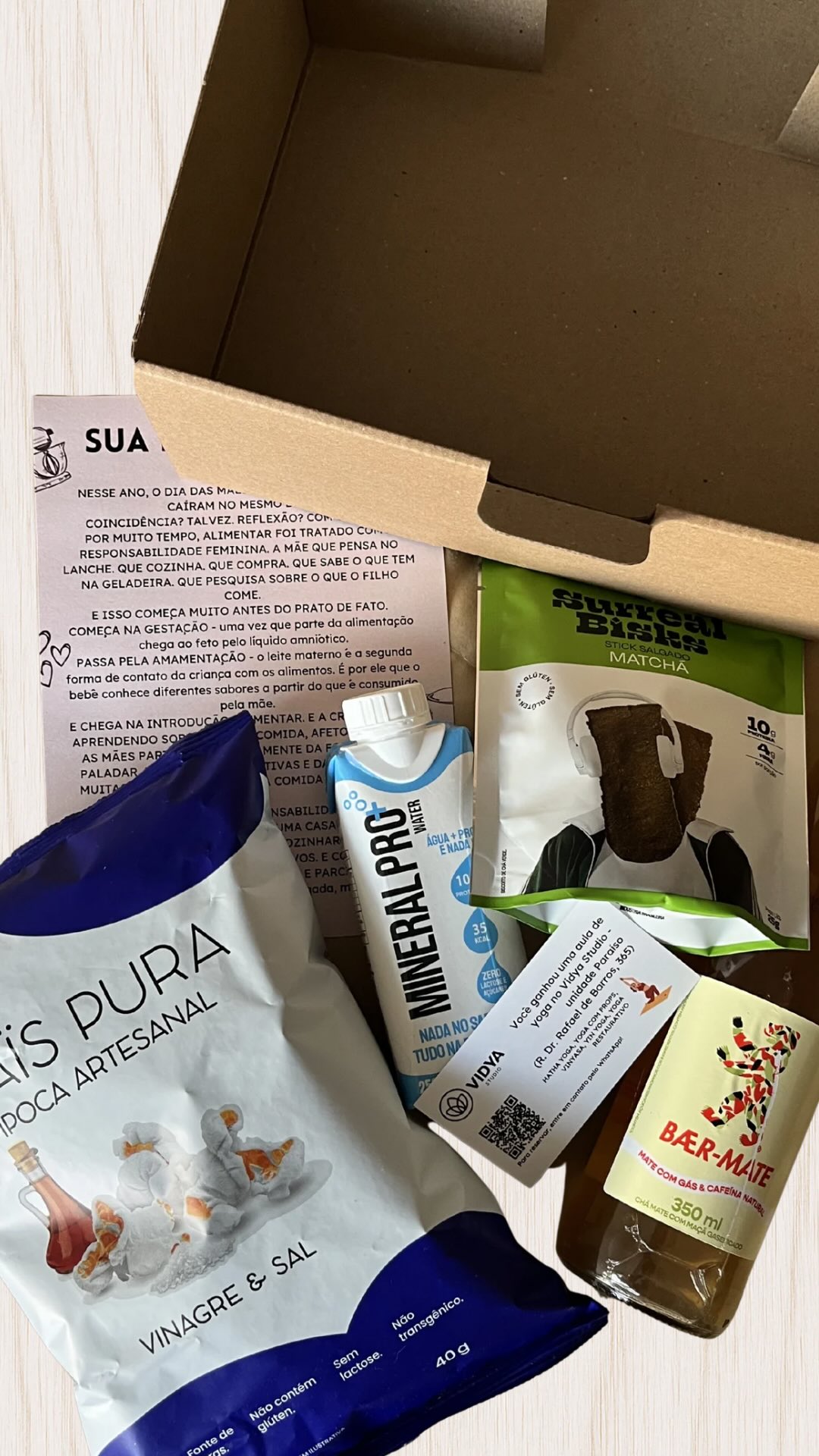 A Gi te Envia de maio tem snack de matchá da @surrealbisks.snacks, pipoca de vinagre da @maispura (a minha favorita), bebida gaseifica de mate da @baermate, água proteica da @mineralpro.water e uma aula de yoga sem aquecimento no @vidya.sp.paraiso