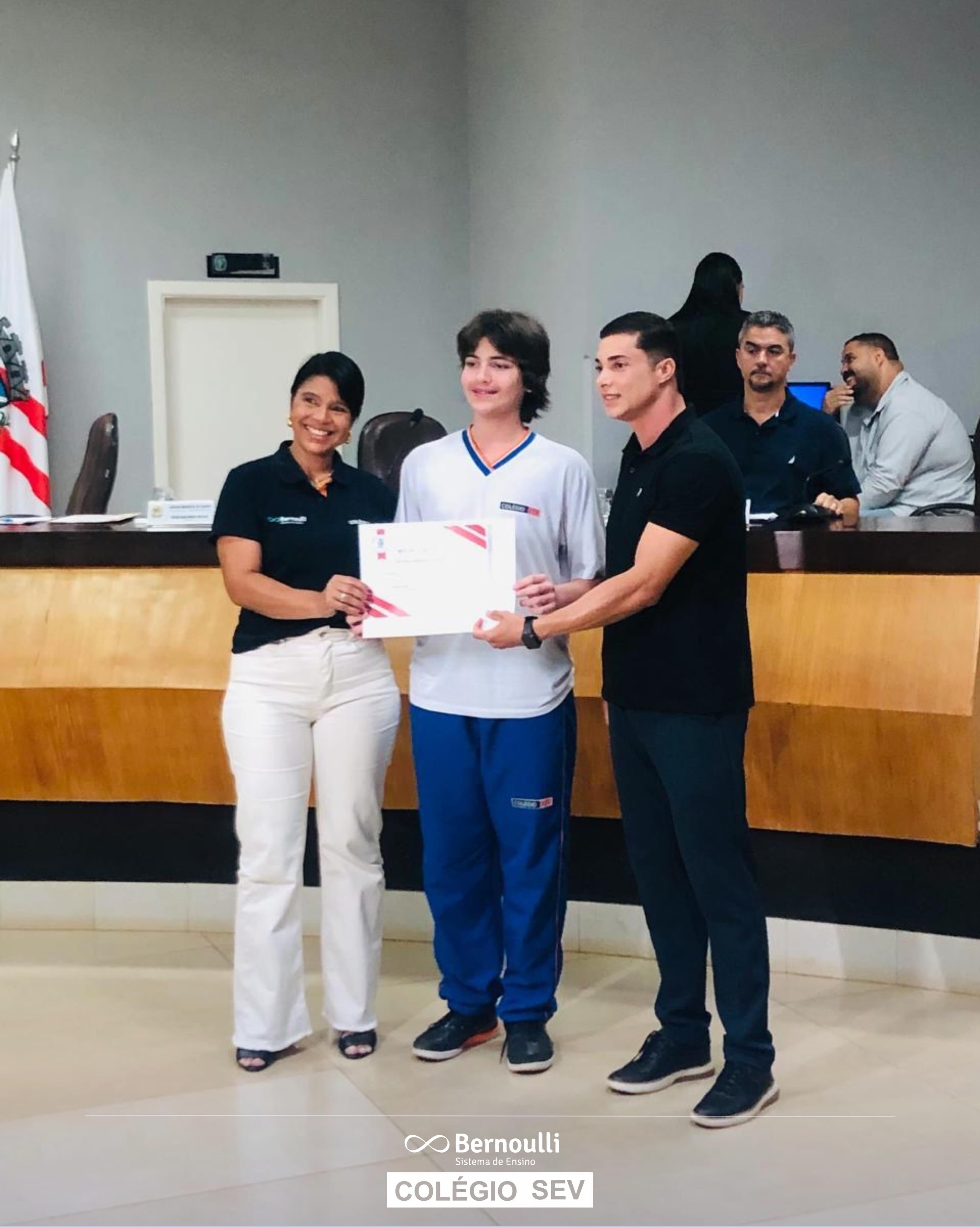 Orgulho que inspira!
No dia 1º de junho, na Câmara Municipal de Vazante, o aluno Davi de Oliveira Ferreira recebeu uma Moção de Aplausos em reconhecimento à participação dos estudantes do Colégio SEV nos JENG 2026 – Jogos Estudantis de Minas Gerais.
Representando todos os alunos da nossa escola que participaram da competição, Davi recebeu a homenagem em nome da delegação do Colégio SEV, simbolizando o empenho, a dedicação e o espírito esportivo demonstrados por nossos estudantes durante a competição.
Parabenizamos Davi e todos os nossos atletas que levaram o nome do Colégio SEV com orgulho, compromisso e excelência.
Parabéns a todos!
