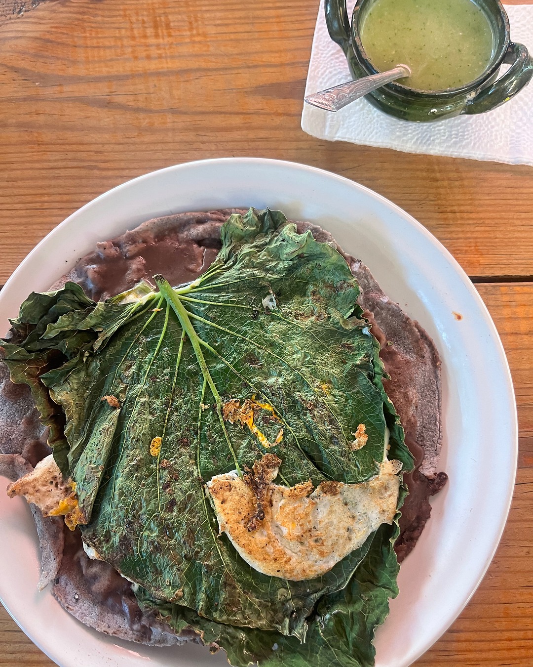 An egg cooked in a heart-shaped hierba santa leaf is my grounding meal. The next installment of Tragona takes you to La Cosecha Organic Market in Oaxaca. Link in Bio #Tragona #drinkaseat