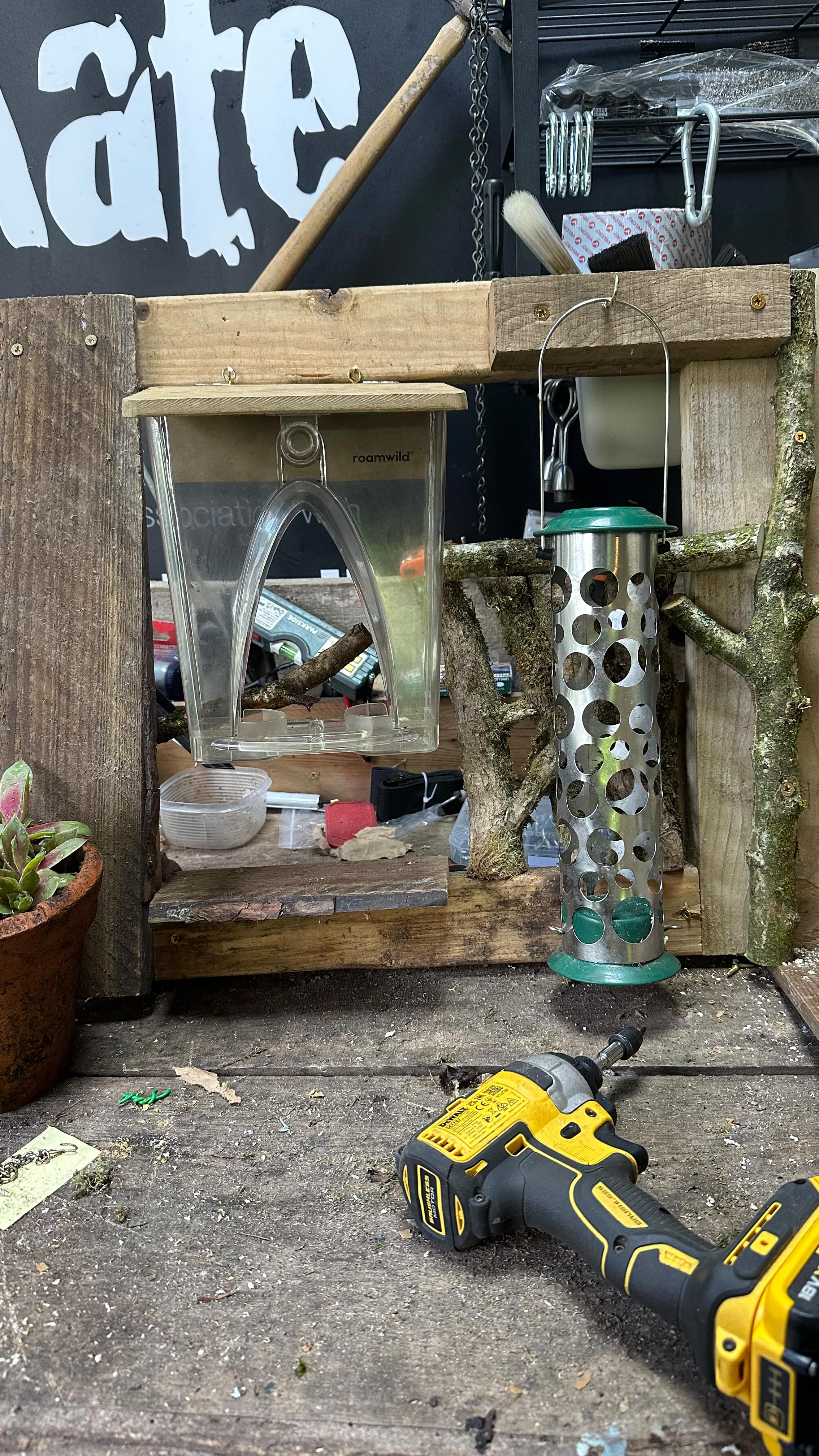 This is one of my most successful set-ups.
For many years, I have been using old dog crates to create feeding stations. They keep squirrels and bigger birds out.
If the holes are bigger on the base, you may need to put chicken wire on that section.
Some crates have a plastic base which can be used as a roof. Otherwise, a plastic desk chair mat works well.
This afternoon, I built a frame that fits at the end of the crate. It makes it easier for me to hang feeders and remove them easily for cleaning.
The birds love it!
This feeding station live streams on my website. 😀