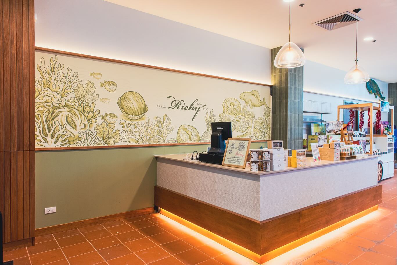 Project: Wall Design & Wall Painting – 📍Richy Trang, Trang International Airport Branch
Farg Design Studio had the opportunity to collaborate with Khun Pa Aeng, the owner of Richy, one of Trang’s most well-known local restaurants and souvenir brands. For this project, our team was commissioned to design and create a custom wall artwork for the Richy branch located at Trang International Airport.
The design concept was inspired by the idea of creating a memorable first impression for visitors arriving in Trang. By combining elegant line-art illustrations with realistic floral paintings, we developed a visual experience that reflects both the warmth and unique identity of the province. The artwork was carefully designed to serve as a welcoming landmark within the space, allowing travelers to instantly feel that they have arrived in Trang.
Beyond enhancing the interior atmosphere, the wall design also functions as a distinctive visual feature that strengthens the brand identity of Richy while creating an engaging and photogenic environment for customers.
Project Type
Commercial Interior Wall Design & Wall Painting
📍Location
Richy Trang – Trang International Airport, Trang, Thailand
@richy.trang1990
#walldecor #เพ้นท์ผนัง #wallart #wallpaintingart WallPainting walldesign fargdesignstudio