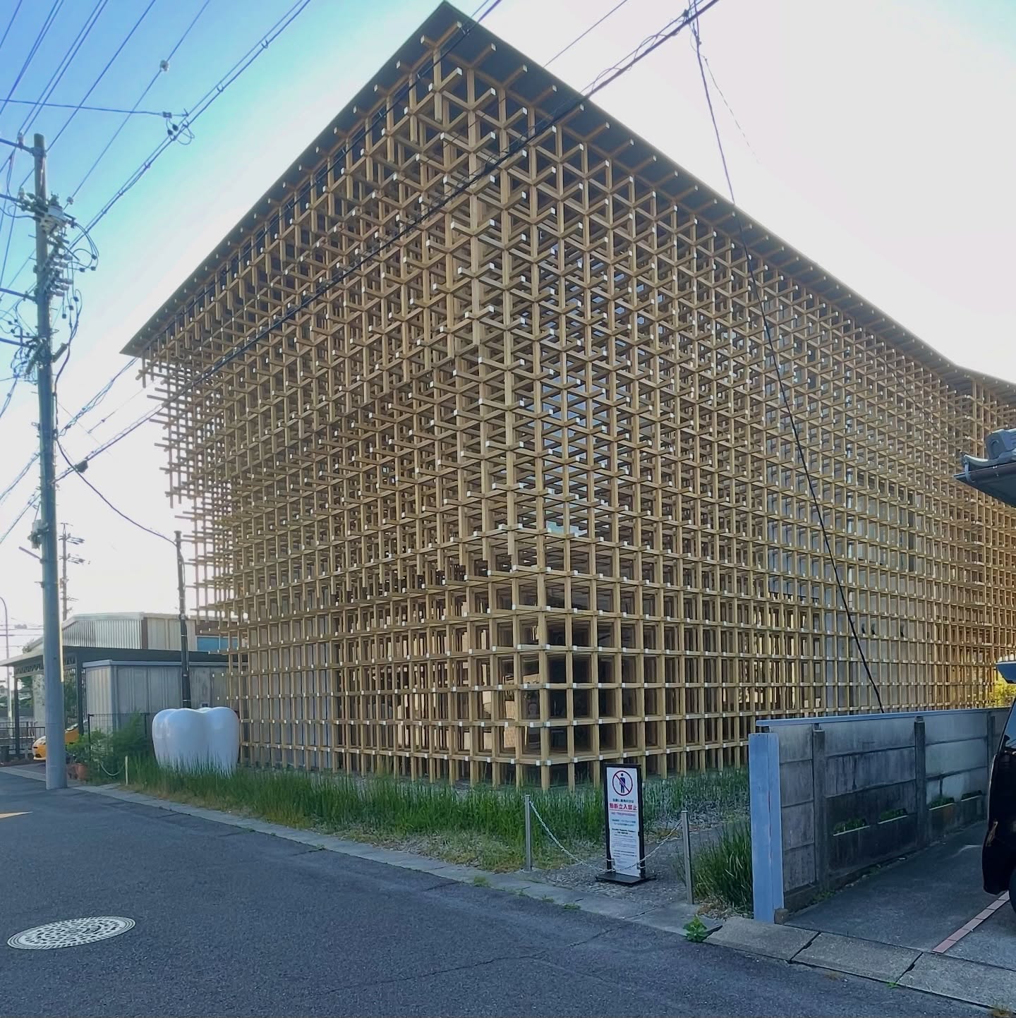 春日井市住宅街に木の塊
GCプロソミュージアム・リサーチセンター|隈研吾(2010)
飛騨高山に伝わる木のおもちゃ「千鳥」を原型に、60mm角のヒノキを釘も金物も使わず三次元に組み上げた格子の建築。
近づくほど、内と外の境界が静かに溶けていく。
線の隙間を光が通り抜け、影が幾重にも重なって、立っているだけで構造そのものを体感できる。
細い線の集積が豊かな奥行きをつくるのか——
#隈研吾 #GCプロソミュージアム #春日井市 #千鳥格子 #建築探訪