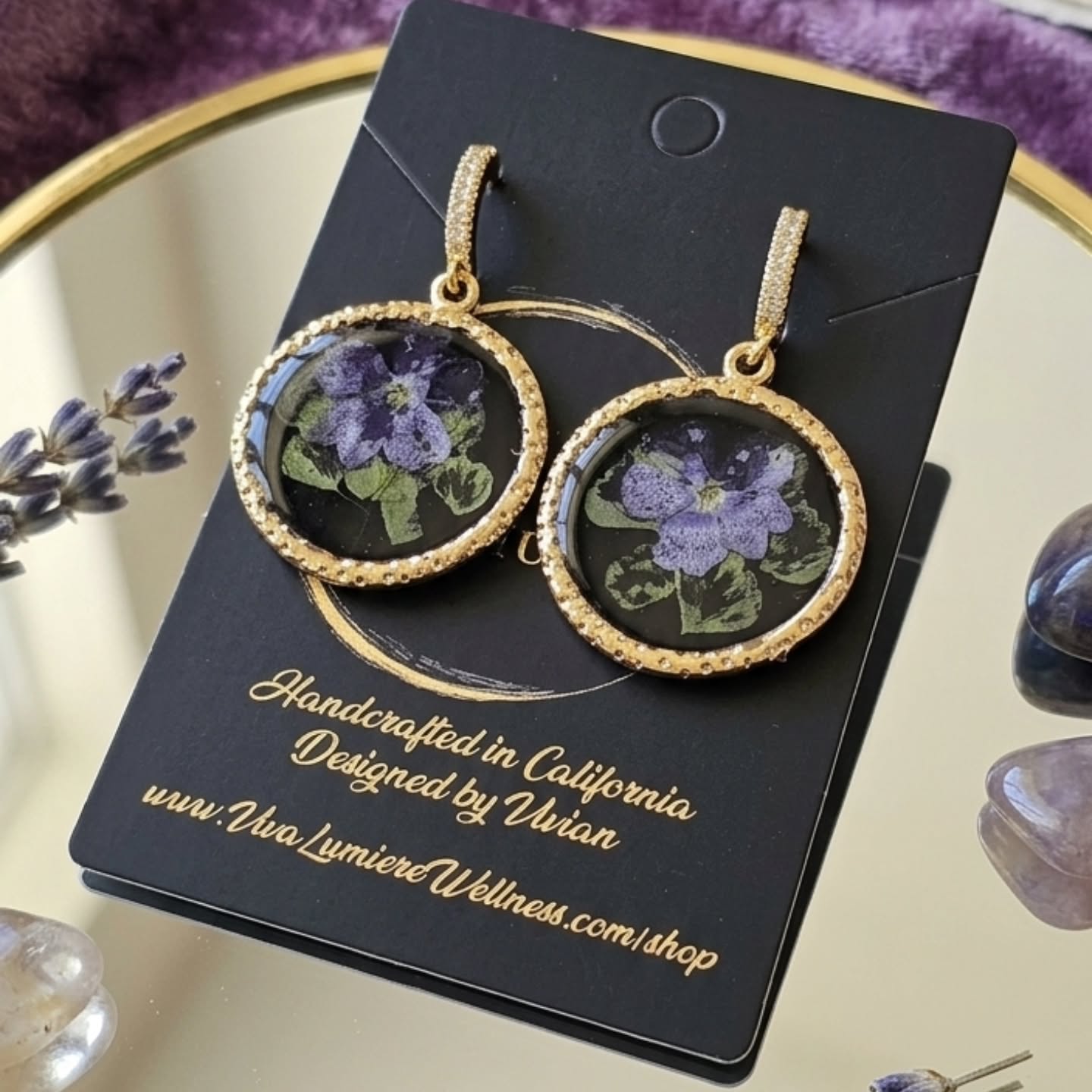 Botanical Elegance: Pressed Violet Drops
Freshly finished today! I am so excited to share my newest handcrafted creation—a perfect blend of vintage charm and modern elegance.
These stunning round drop earrings feature delicately preserved purple blooms set against a deep, dramatic background, framed beautifully in a shimmering, textured gold border. Completed with sparkling, pave-lined huggie hoops, they add the perfect touch of sophisticated romance to any outfit.
Meticulously designed and handcrafted by Vivian right here in California, each pair is completely unique.
**Bring a piece of nature’s beauty home:** www.VivaLumiereWellness.com/shop
#HandmadeEarrings #FloralJewelry #PressedFlowers #ResinArtJewelry #VivaLumiere