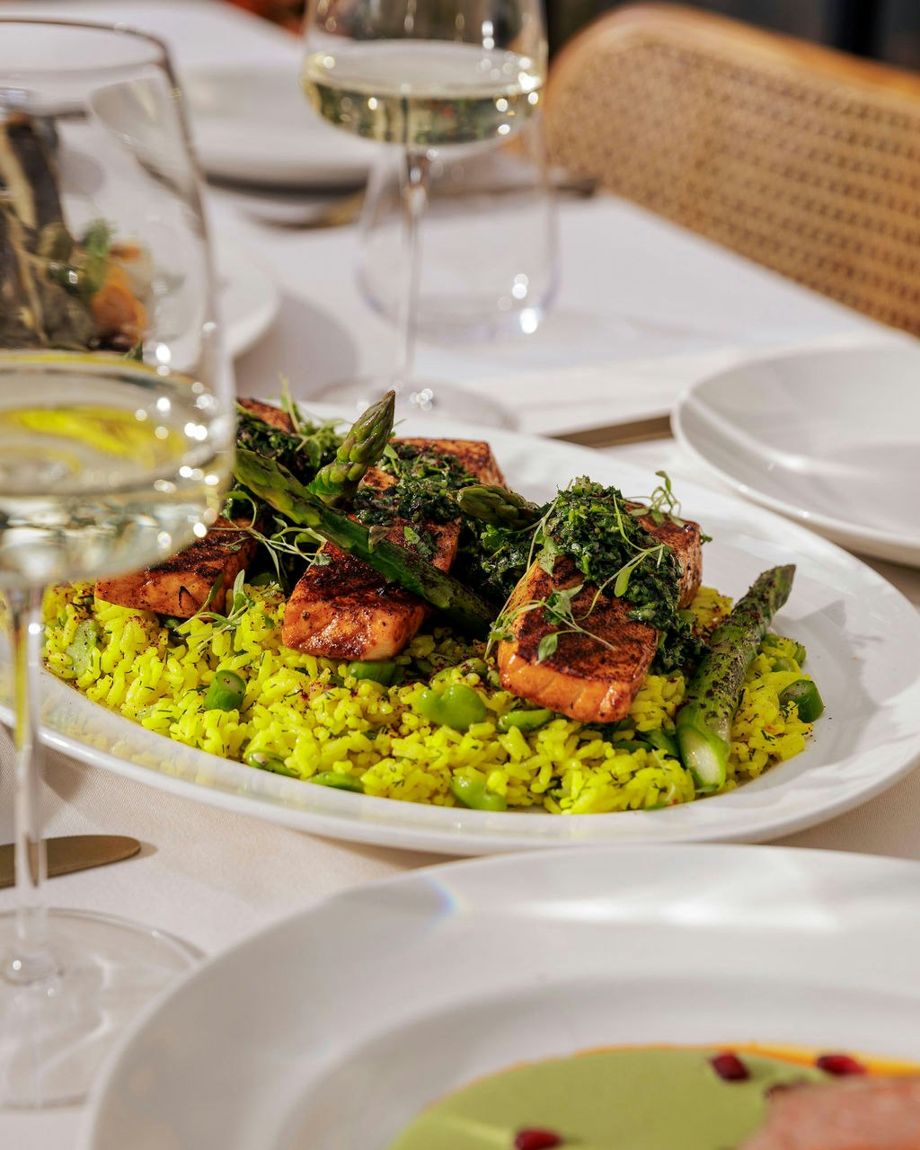 Light, vibrant and full flavour. Roast salmon fillet with black lime, saffron rice, green beans, asparagus and mint gremolata - a dish that speaks to the season as much as the setting. ✨