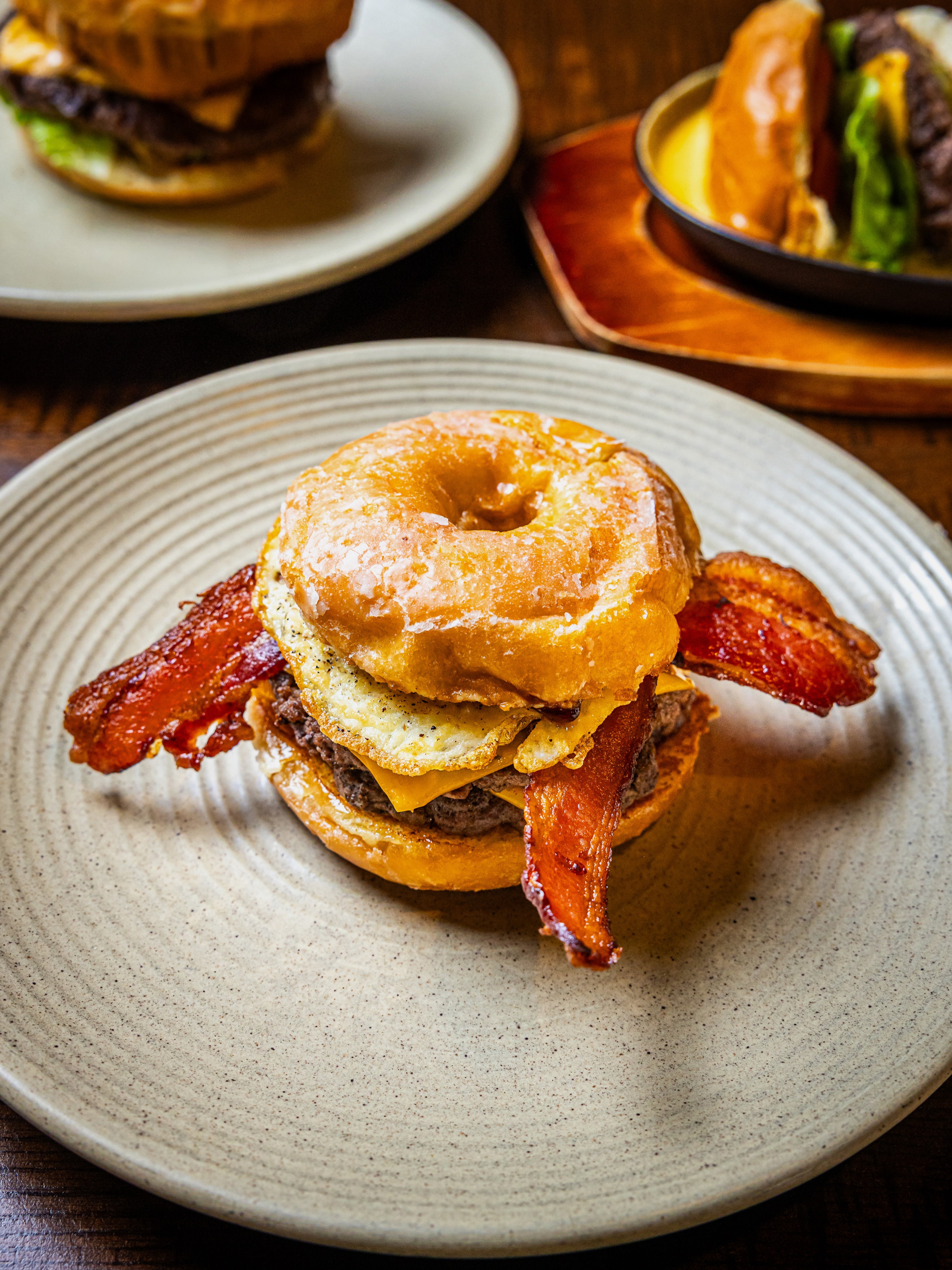 come try our sweet outlaw burger 🤠🍔a glazed donut bun stacked with berry jelly, crispy bac....