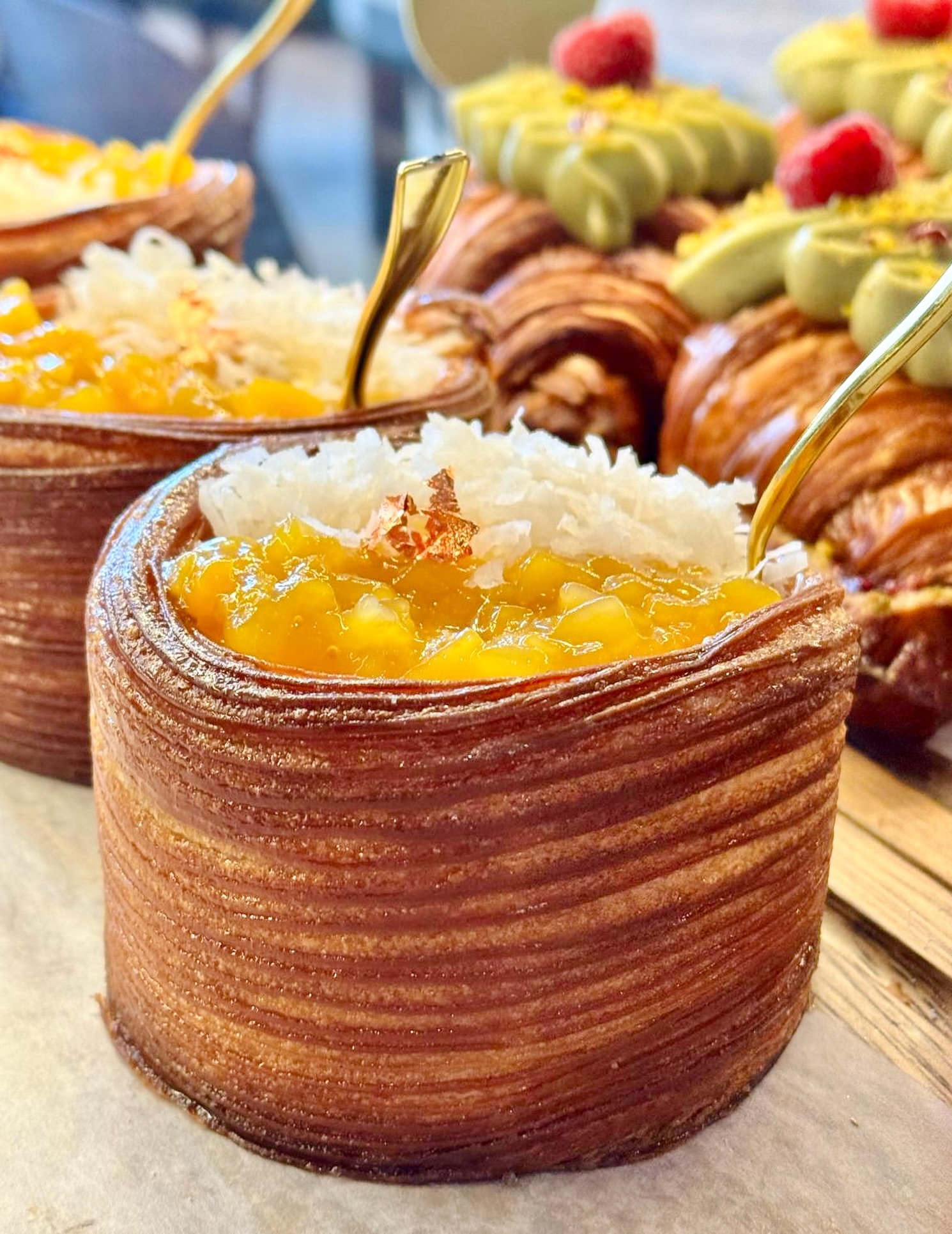 Mango cream, caramelized mango, coconut flakes on croissant dough. Summer tastes like this 🥭🥥