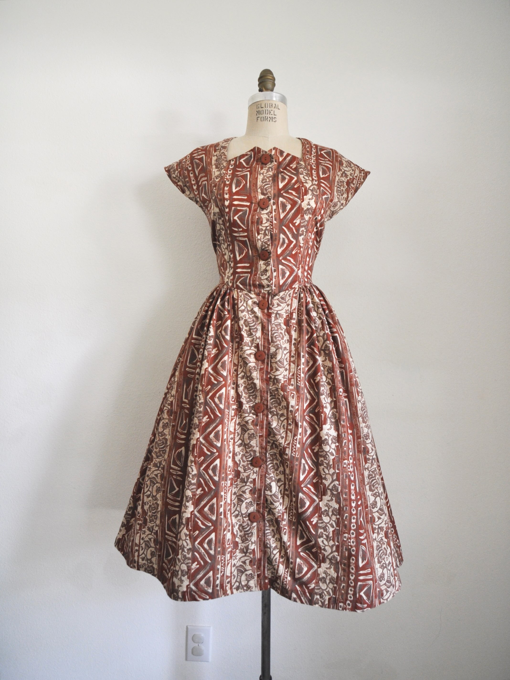 Link in bio to shop! Lovely cotton dress with mixed print. Functional buttons, gathered skirt. Side ties to cinch. Bust: 34/35” Waist: 28-30” Length: 46” Shoulder to waist: 16”