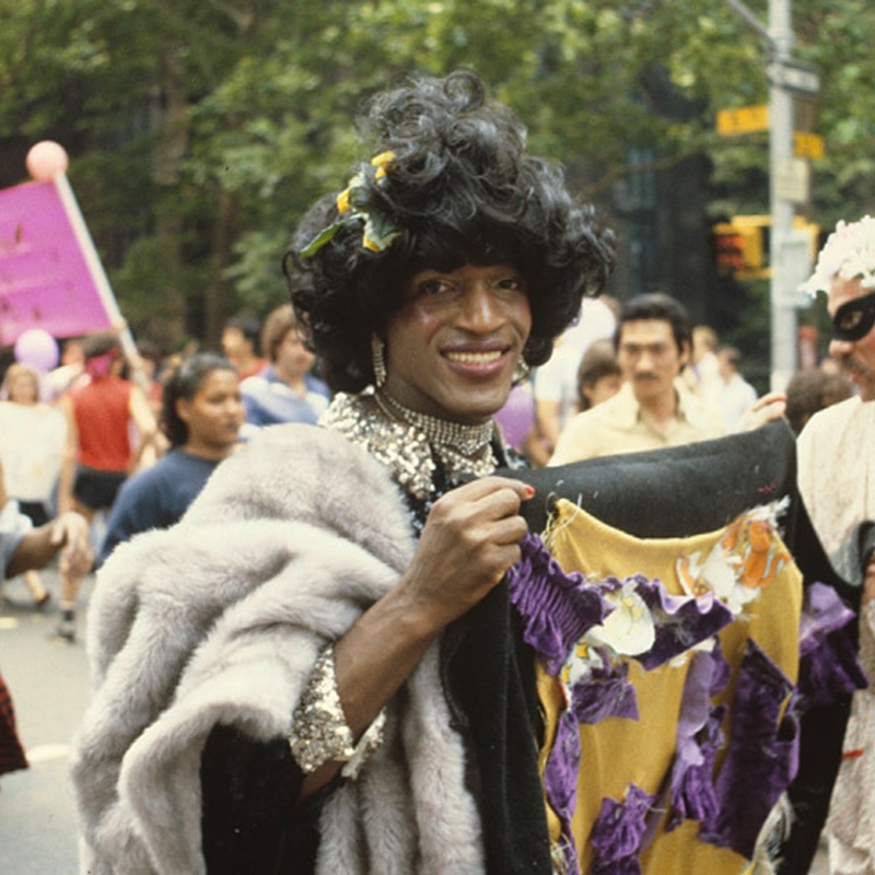 Itโs Marsha P. Johnson Day!
Marsha P. Johnson was an American LGBTQ+ activist, performer, and community leader who played an important role in the fight for gay and transgender rights. Johnson moved to New York City in the 1960s, where she became a well-known figure in the cityโs LGBTQ+ community. Johnson is often associated with the Stonewall Inn and the 1969 Stonewall uprising, a series of protests that helped launch the modern LGBTQ+ rights movement.
While stories differ about her exact role on the first night, historians agree that she became a leading activist in the movement that followed.
Along with Sylvia Rivera, Johnson co-founded Street Transvestite Action Revolutionaries (STAR) in 1970. The organization provided shelter, food, and support for homeless transgender and gender-nonconforming young people.
Marsha P. Johnson was also known for her vibrant personality, distinctive flower-crowned style, and dedication to helping others. She remained active in LGBTQ+ advocacy and AIDS activism throughout the 1980s. She died in 1992, and although her death was initially ruled a suicide, the case was later reopened after concerns were raised by friends and activists.
Today, Marsha P. Johnson is remembered as a symbol of courage, compassion, and the ongoing struggle for equality. Her legacy continues to inspire people working for LGBTQ+ rights and social justice around the world.