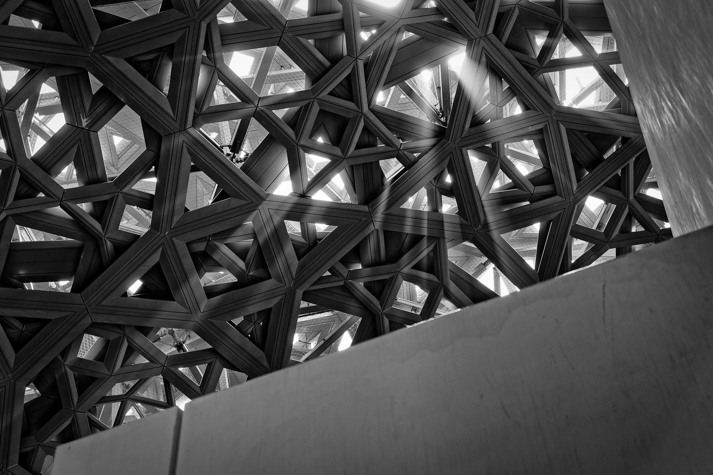 I don't shoot black and white often, but this one demanded it. Standing under the dome of the Louvre Abu Dhabi, watching sunlight pour through thousands of star-shaped openings, there was no version of this in color that would've done it justice.
Designed by Jean Nouvel, the dome is made up of 7,850 unique metal stars layered across eight strata, engineered so light filters through the way it would through palm fronds in a desert oasis. It's actually called the "Rain of Light," and standing beneath it, you understand exactly why.
#louvreabudhabi #abudhabi #architecturephotography #blackandwhite #rainoflight